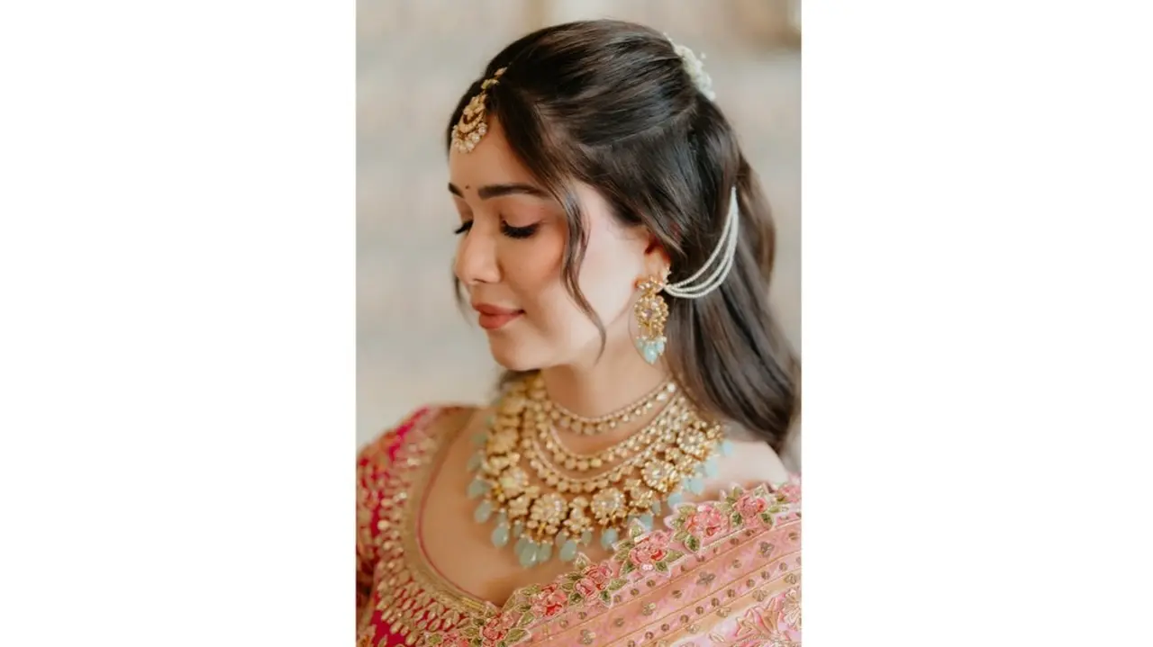 Sara chose a vibrant traditional pink saree adorned with intricate embroidery and gold zari work. She elevated the look with a statement maang tikka, a heavy necklace, and dangling earrings.