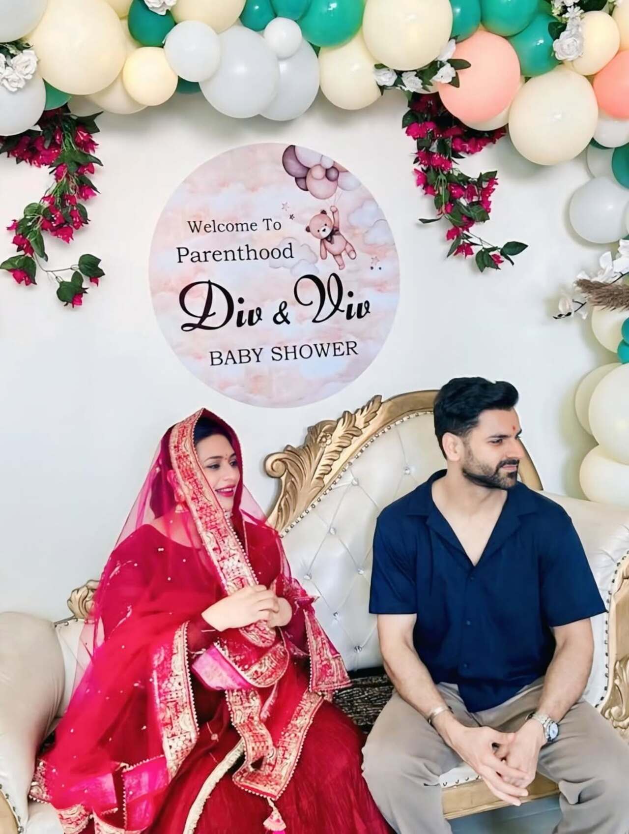 The decor featured a pastel-themed setup with balloons in soft hues of green, cream, and peach, along with a wall decoration that read, “Welcome to Parenthood Div and Viv.”