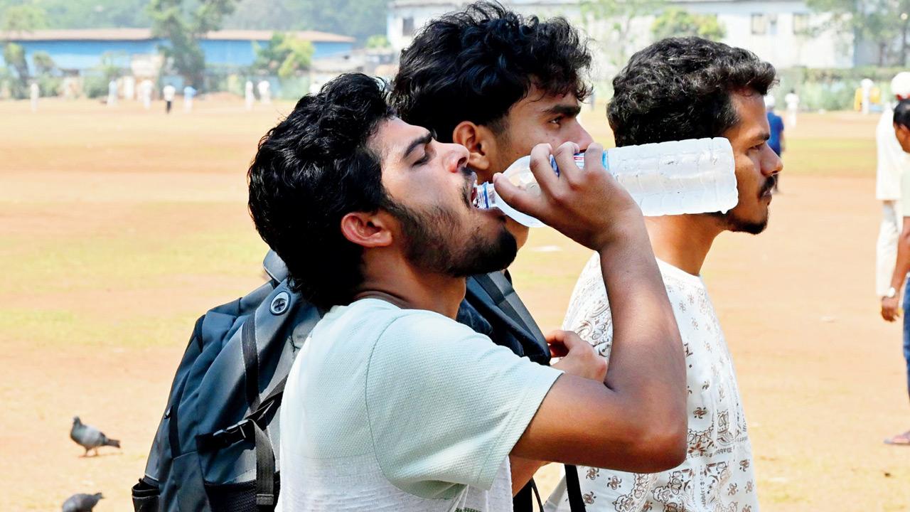 A man drinks water to combat dehydration due to heat