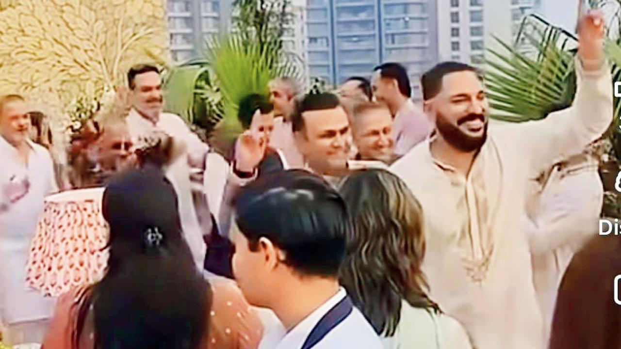 Former cricketers Yuvraj Singh (right) and Virender Sehwag (behind Singh) at the celebration. Pic courtesy/Youtube