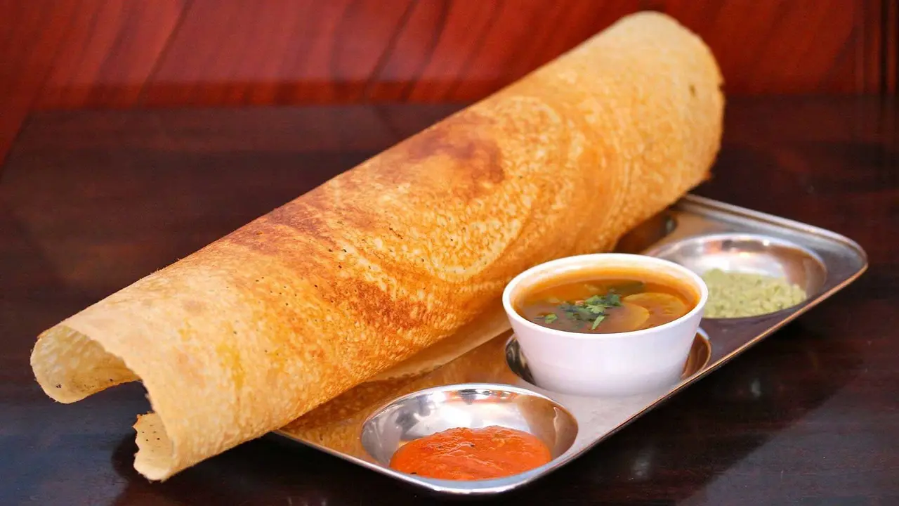 Tomato dosaChef Chinna Karuppan, Master Chef South Indian at CUR8, Four Seasons Hotel Bengaluru highlights the tomato dosa, which is one traditional favourite but he believes is lesser-known. While regular dosa is a staple in most Indian homes, tomato dosa is made when families want something slightly tangy and sweet but full of flavour. It’s prepared using the usual rice and urad dal batter, but with freshly ground tomato purée and red chillies added in. The tomatoes give the dosa a soft texture, a mild sweetness and a beautiful reddish colour. This variation is especially popular in Andhra Pradesh, where bold and tangy flavours are loved. It likely comes from the simple idea of using ripe, seasonal tomatoes to add a twist to the everyday dosa. Tomato dosa is usually served hot with coconut chutney or spicy podi, making it a comforting and flavourful meal (Image for representational purpose only)