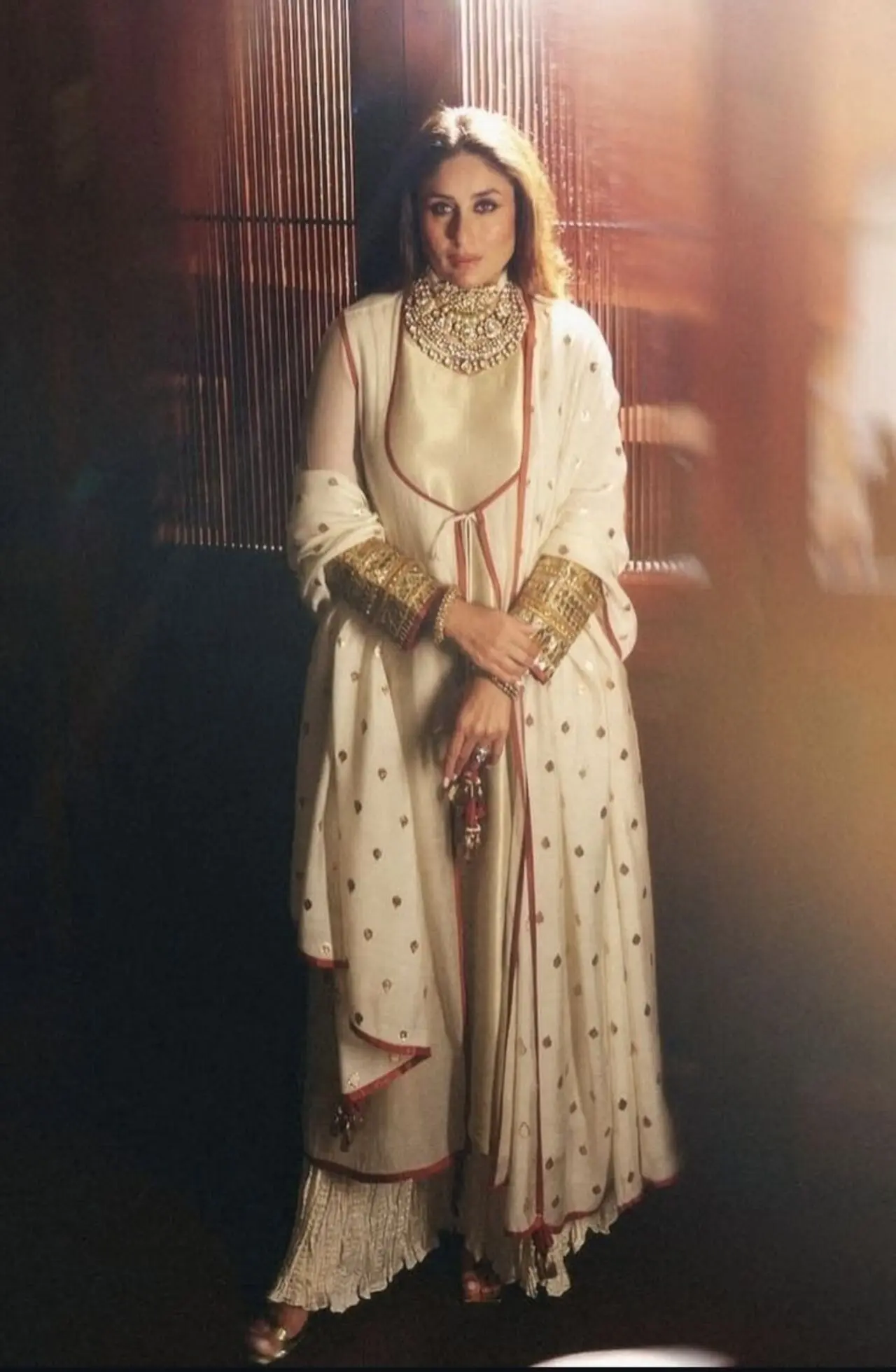 Kareena Kapoor stuns in an ivory jacket-style kurta set featuring a double-layered jacket-style kurta made of cotton silk, paired with a tissue inner kurta and crushed Dhaka pyjama pants. 