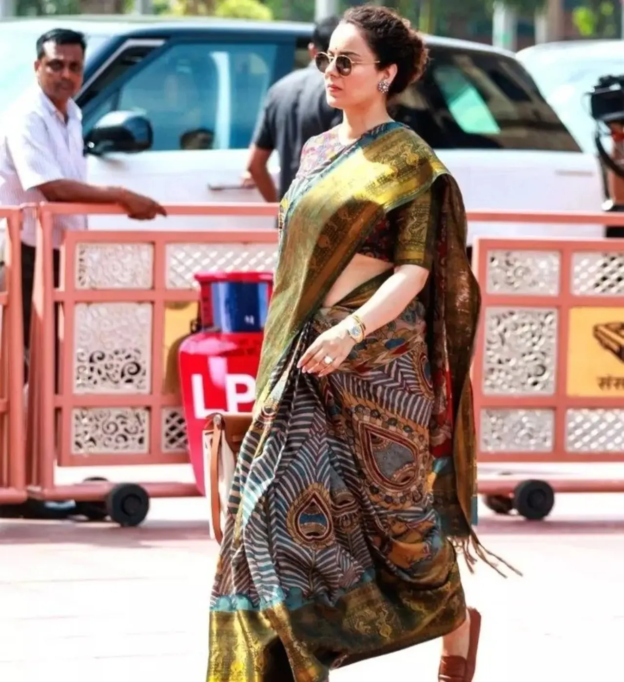 Kangana adorns a Srikalahasti Pen Kalamkari saree, a traditional Indian craft where the artwork is hand-painted using a bamboo pen, crafted from Tussar silk or Linen silk. She pairs it with a matching kalamkari blouse.