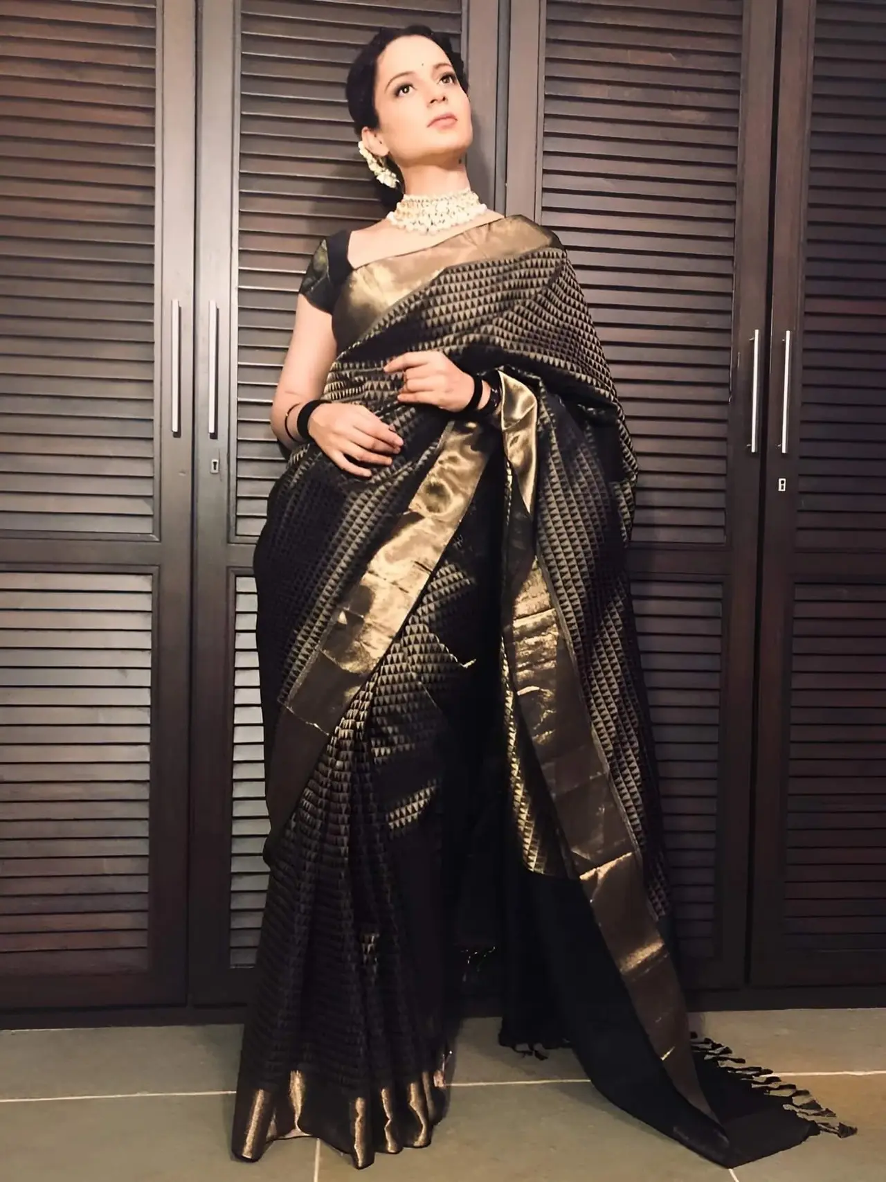 Kangana stuns in this handloom kanjivaram saree with black and gold zari pattern woven throughout the body. The design is highlighted by its intricate Jacquard weave and heavy gold zari borders.