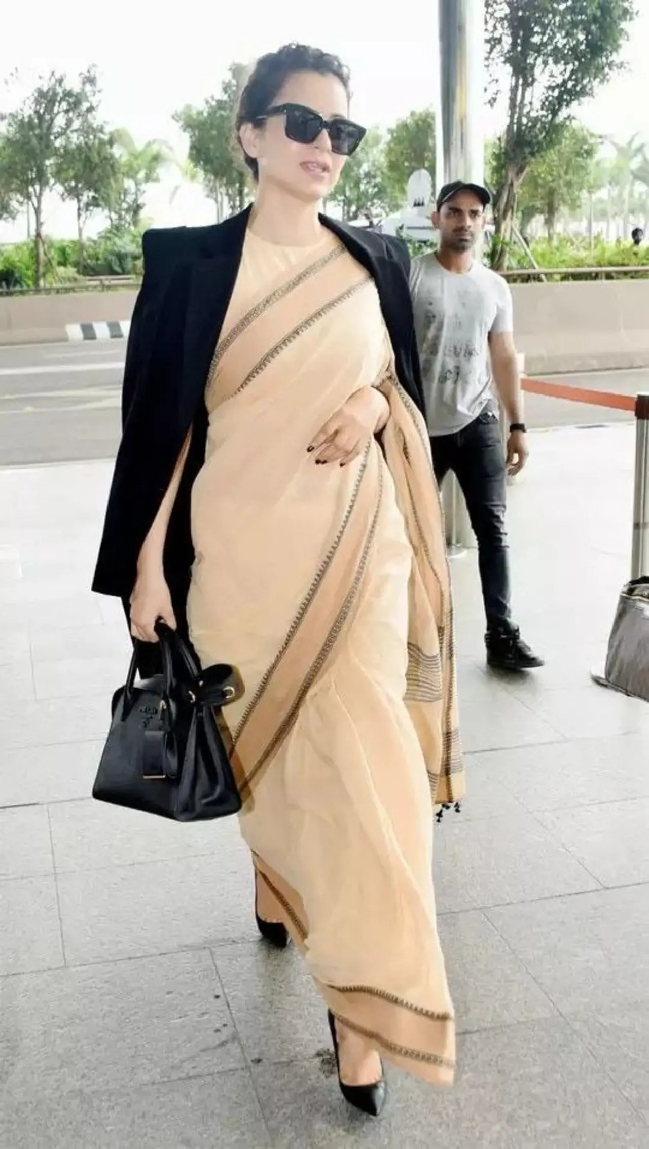 Kanagan's lightweight handloom cotton saree, originally purchased to support local weavers from Kolkata, defines comfort in drapes. It has a minimal, solid peach body with a thin contrast border featuring delicate stripes.