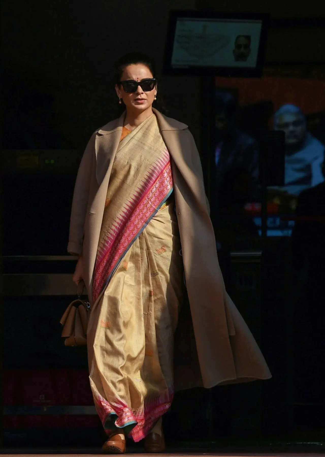 Kangana Ranaut made a style statement in this beige handloom saree styled with a long trench coat during a Parliament winter session.