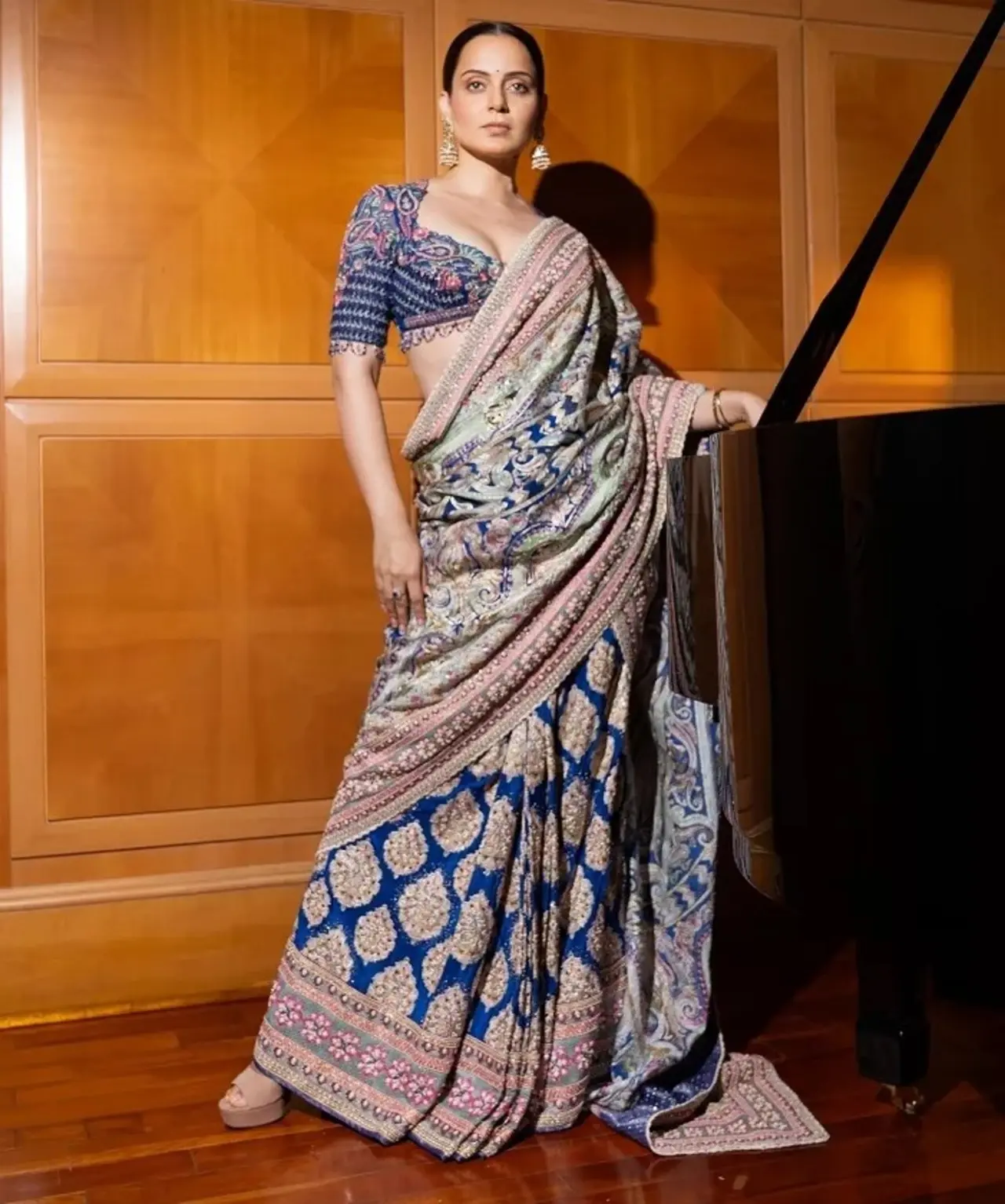 Blending tradition with luxury, Kangana Ranaut wears a royal blue hand-painted saree from Tarun Tahiliani, that features Persian-inspired motifs and geometric patterns.