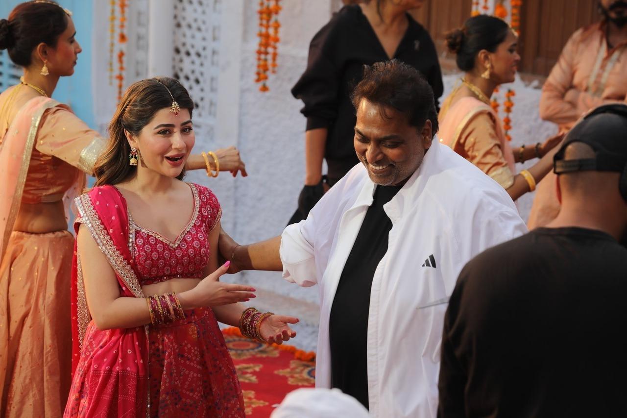 Aditi and Ganesh are caught in a candid moment on the sets with both of them smiling and saying something.