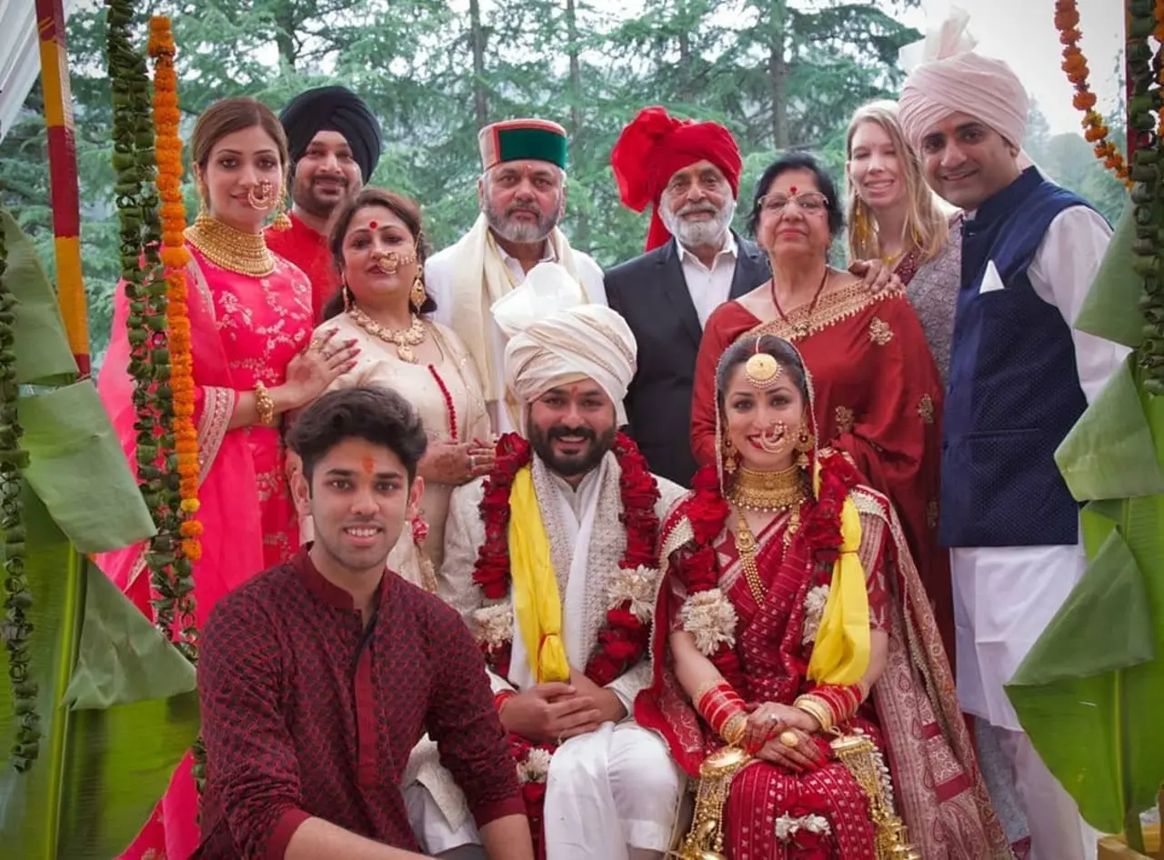 This picture from Yami and Aditya's wedding has them posing with the entire family including Yami's side and his side.
