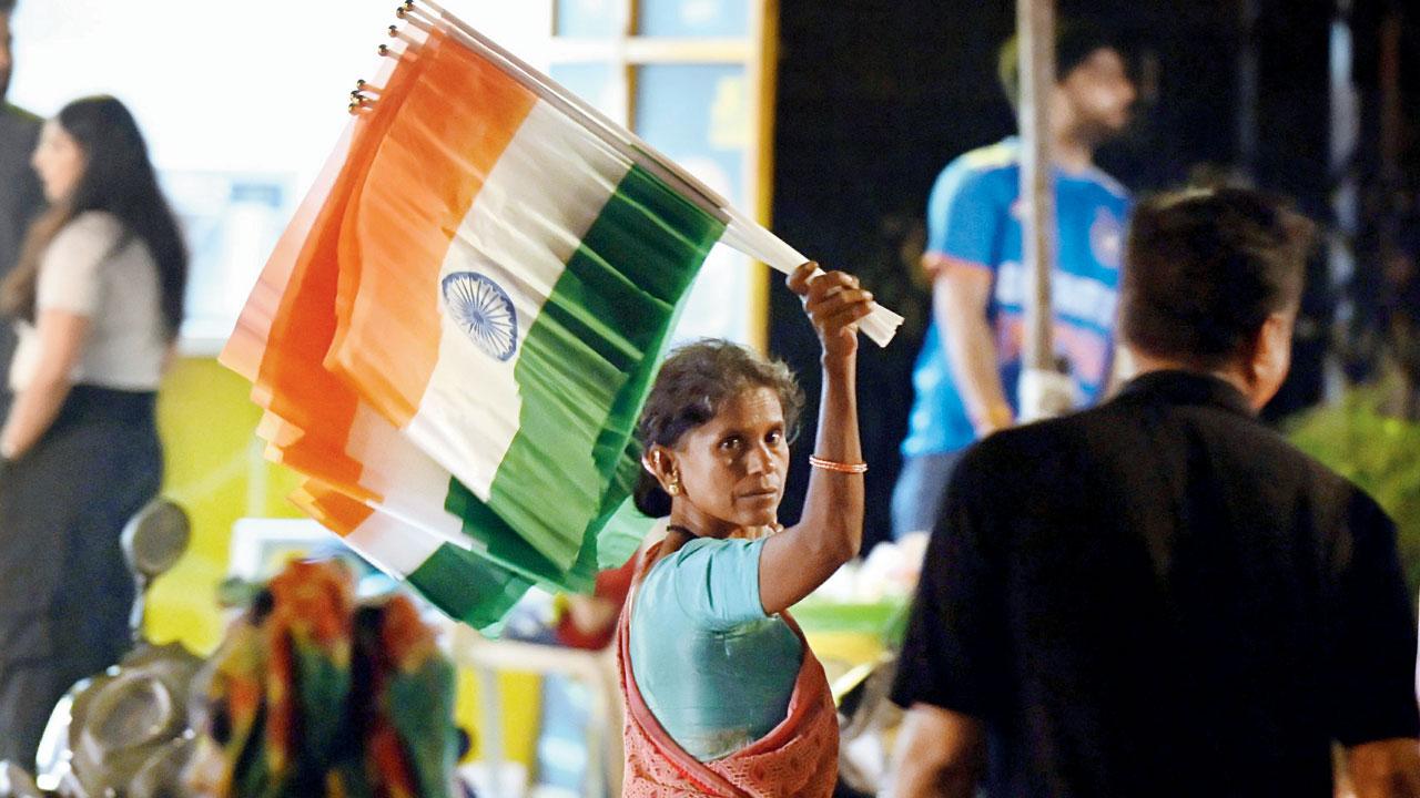 A woman sells national flags as fans celebrate on Borsapada Road, Mahavir Nagar, Kandivli West, after India defeated New Zealand in the ICC Men’s T20 World Cup 2026 final