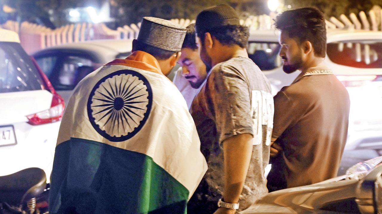 People watch the T20 World Cup 2026 final on a mobile phone at Marine Drive