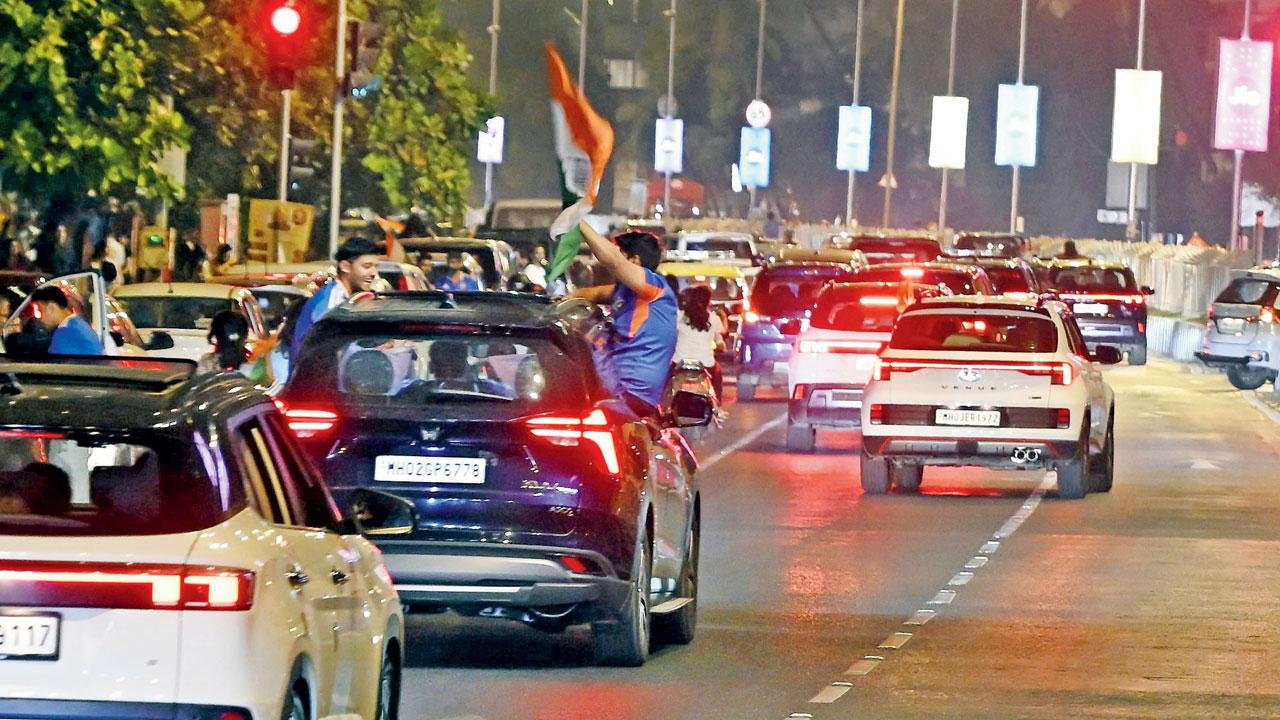Two Indian fans on the window of their cars, celebrating India's historic triumph