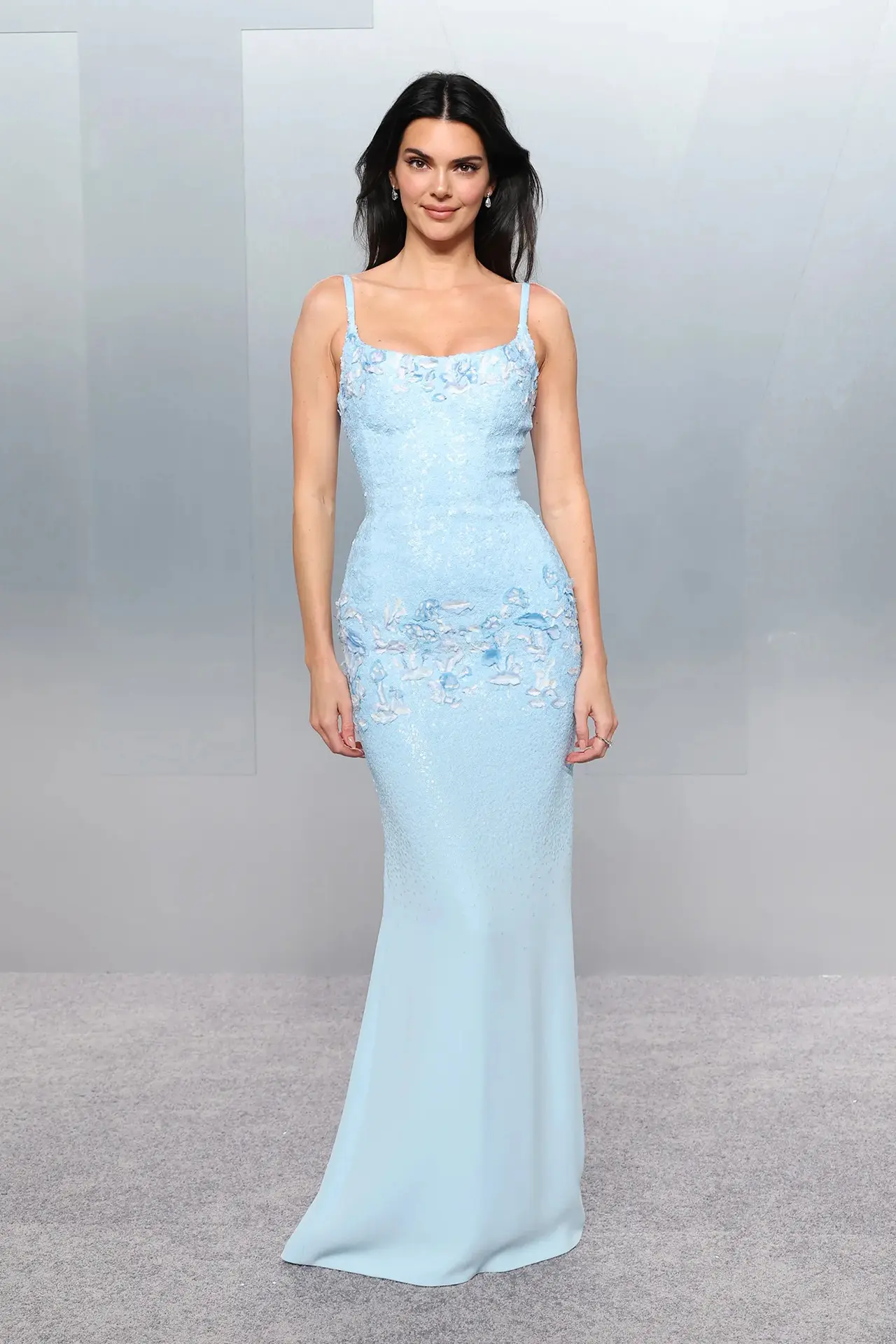 Kendall Jenner turned heads in a bespoke ice blue Chanel gown designed by Matthieu Blazy. The striking creation featured a glacier gradient with delicate floral beading clustered around the neckline and hips.