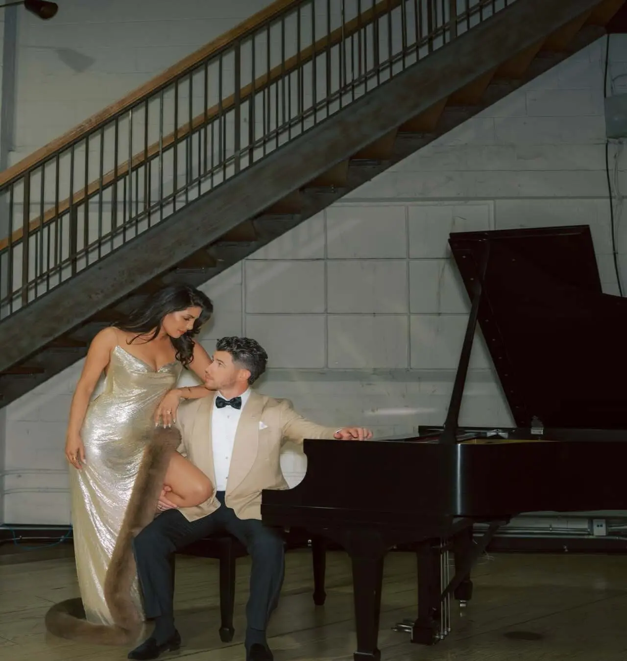 This cinematic photo shows Priyanka leaning slightly on Nick as he sits by the piano. The two are gazing lovingly into each other's eyes, oblivious to the world around them