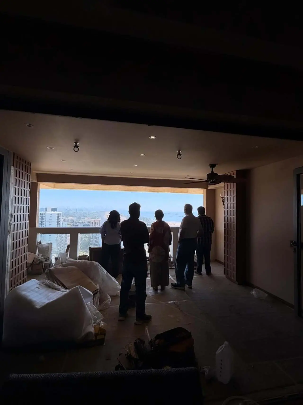 Stunning balcony view: A floor-to-ceiling glass window opens to a city skyline and distant sea, creating a calm, airy atmosphere
