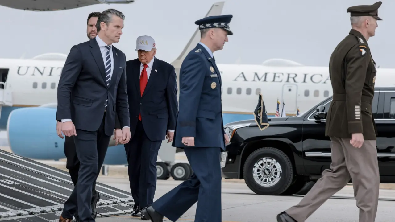 <p>Trump wore a navy suit and red tie along with a white ball cap bearing the word &ldquo;USA&rdquo; in gold lettering</p>