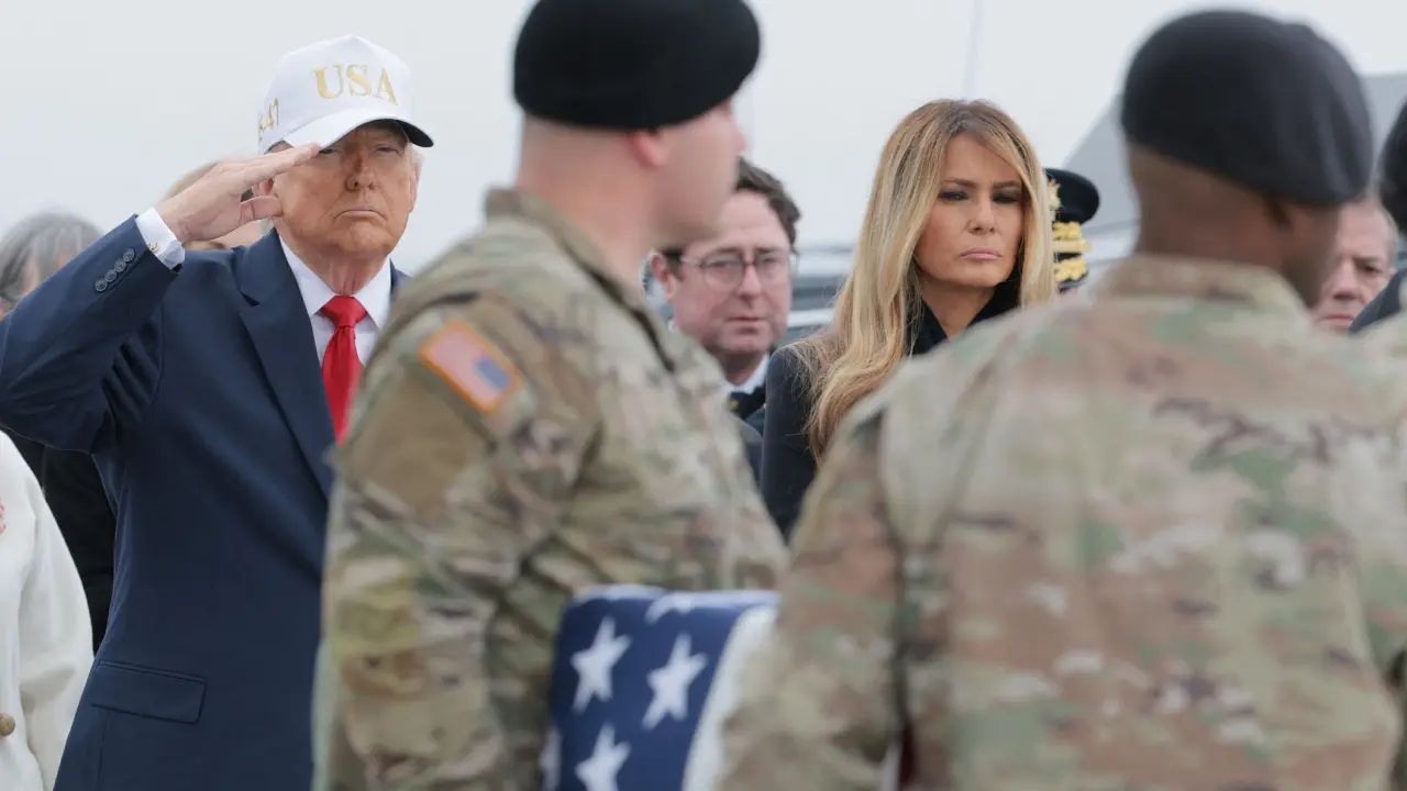 <p>President Donald Trump stood at attention, raising his hand in salute as each case bearing the remains of fallen soldiers was carried past him, families of the dead watching quietly nearby</p>