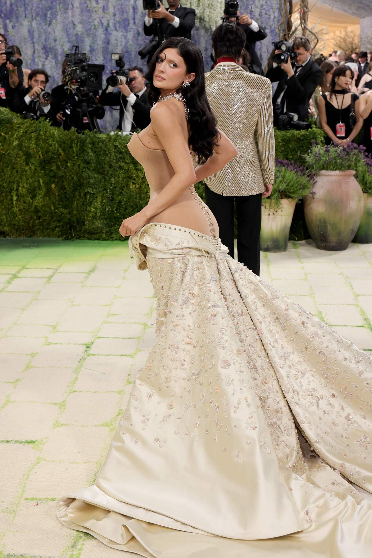 Kylie Jenner pulled off a bold move for her Met Gala look. She wore a Schiaparelli gown, with the front falling down to reveal a nude illusion corset with faux nipples. She upped the ante with dramatic diamond and pearl oversized earrings and a matching collar necklace, but skipped bracelets or rings for the bold look.