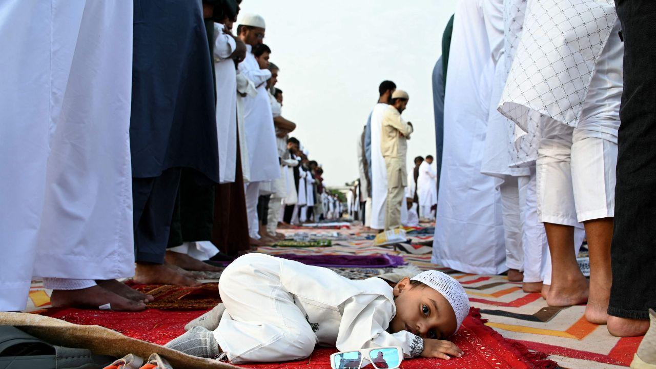 A child looks on as worshippers perform prayers in Hyderabad, capturing moments of curiosity during the celebrations A child looks on as worshippers perform prayers in Hyderabad, capturing moments of curiosity during the celebrations