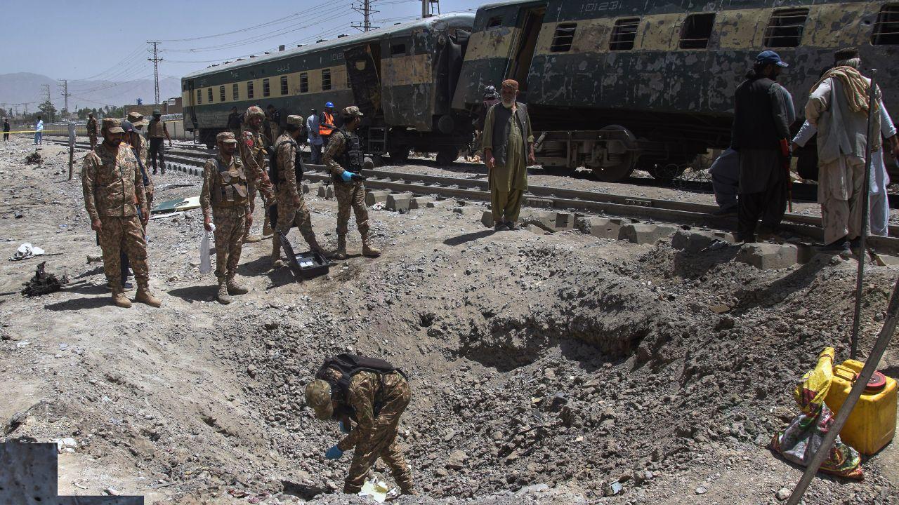 Army officials examine a large crater created by the blast, which officials say was caused by an explosive-laden vehicle hitting the train Army officials examine a large crater created by the blast, which officials say was caused by an explosive-laden vehicle hitting the train