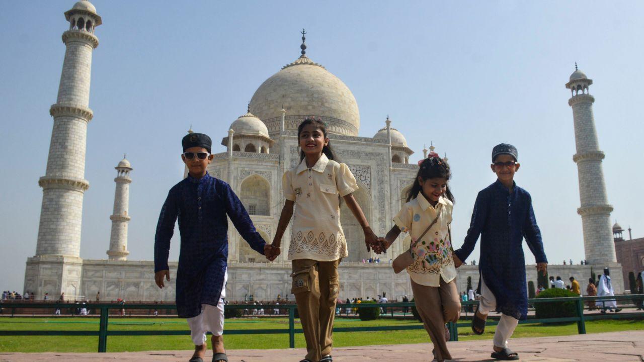 Children dressed in festive attire accompany their families to the Eid prayers in Agra Children dressed in festive attire accompany their families to the Eid prayers in Agra