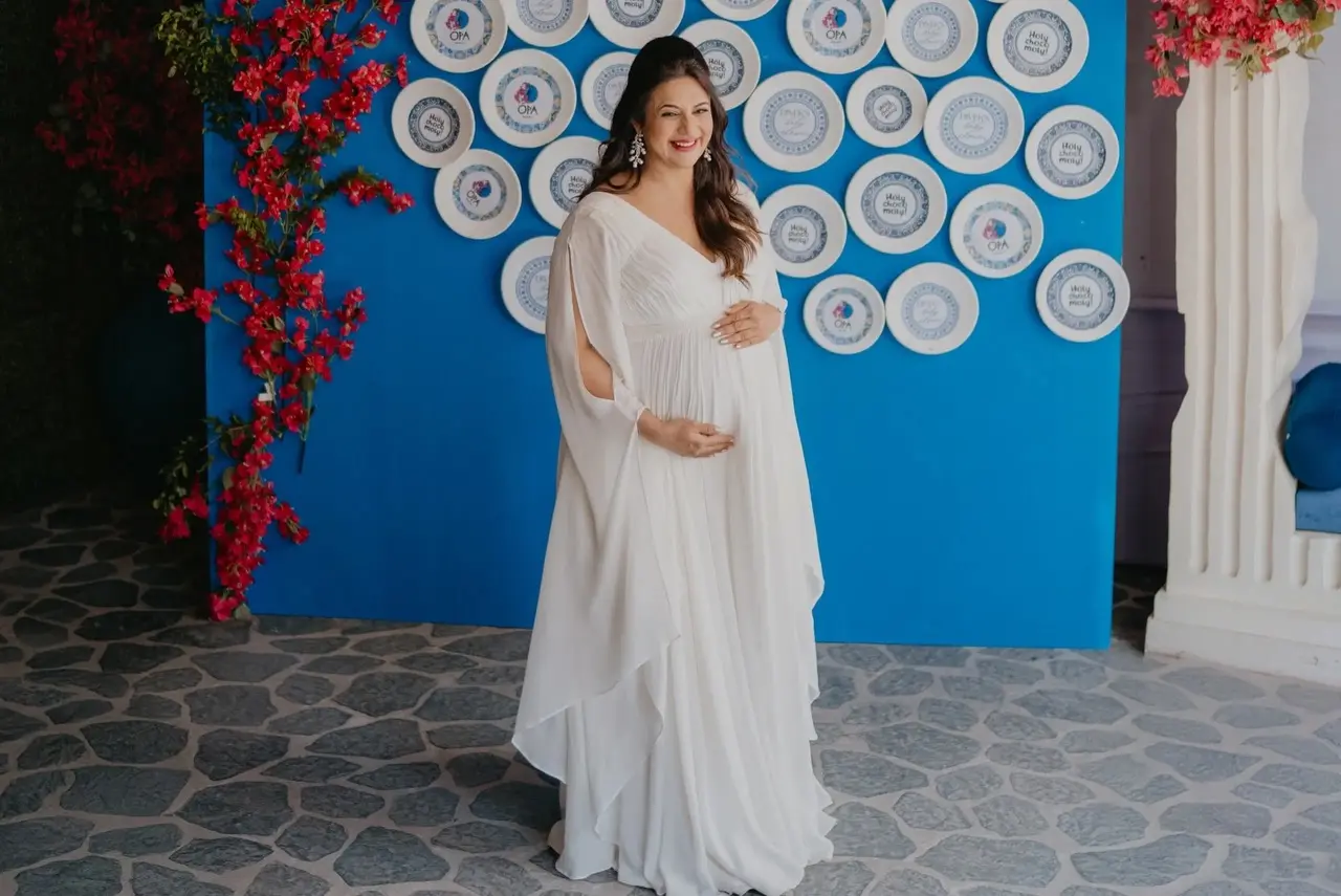 For her baby shower, Divyanka chose to wear a white gown with open hair and light makeup, as she flaunted her baby bump.