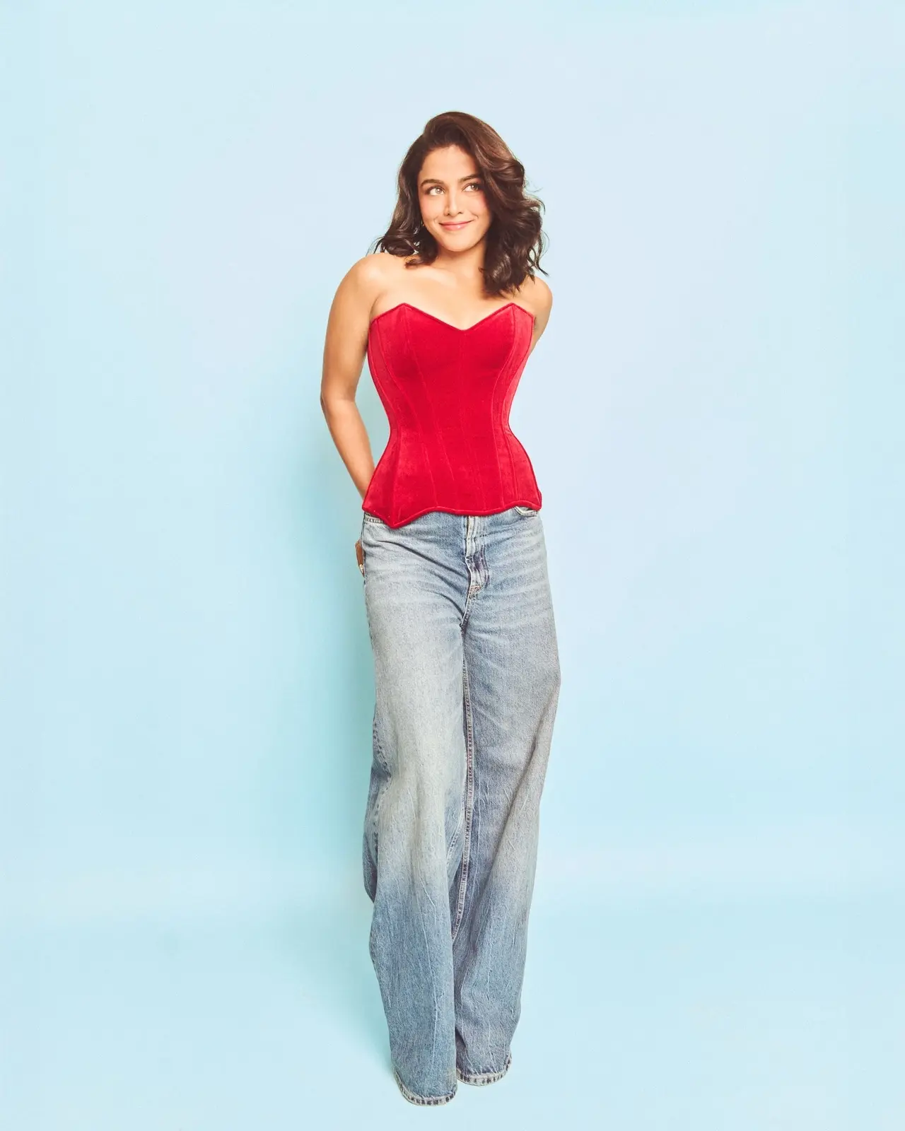 Wamiqa paired a vibrant red velvet corset top with relaxed, wide-leg blue denim jeans. The strapless corset featured a classic sweetheart neckline.