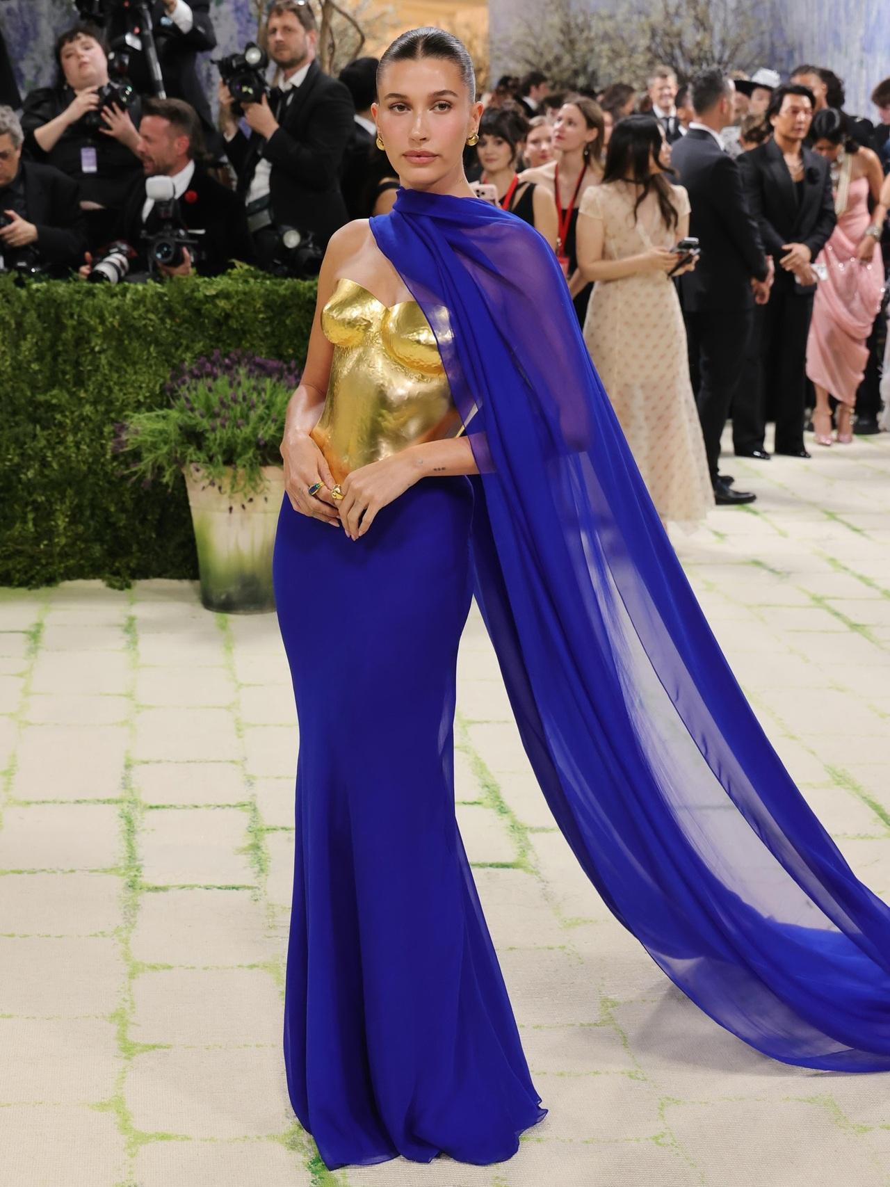 Hailey Bieber
Hailey Bieber never misses when it comes to making a fashion statement. She wore a Saint Laurent outfit that featured a bold strapless gold, armor-like bodice paired with a fitted cobalt blue skirt. She completed her look with chunky gold earrings and a sheer dupatta-style drape across her neckline, giving her appearance a Greek goddess-like feel. Hailey Bieber
Hailey Bieber never misses when it comes to making a fashion statement. She wore a Saint Laurent outfit that featured a bold strapless gold, armor-like bodice paired with a fitted cobalt blue skirt. She completed her look with chunky gold earrings and a sheer dupatta-style drape across her neckline, giving her appearance a Greek goddess-like feel.