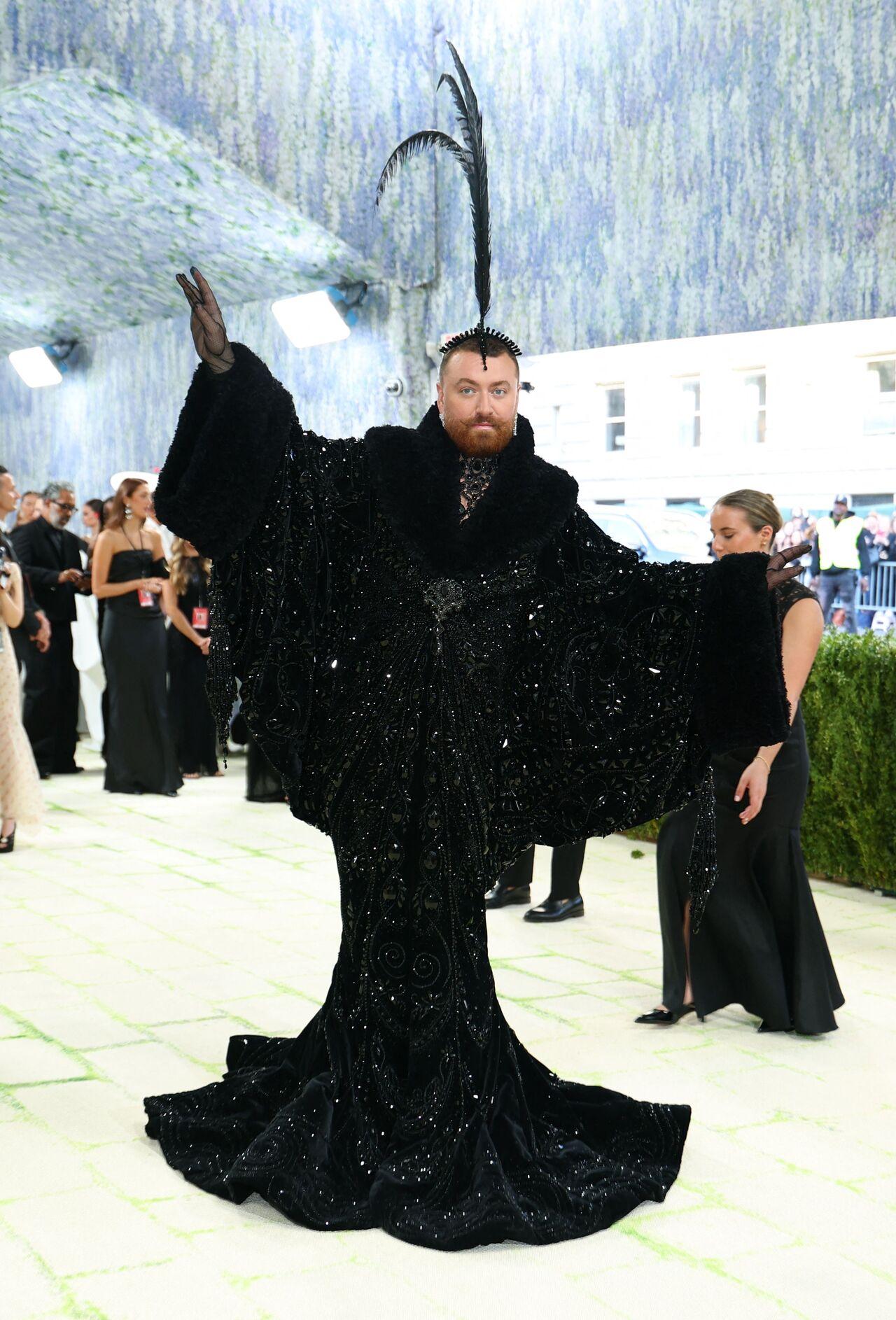 Sam Smith arrived at the Metropolitan Museum of Art in New York City in a black Erte showgirl-inspired mermaid dress complete with a fuzzy collar and sleeves that looked like wings. The 33-year-old, whose outfit was designed by their partner Christian Cowan, completed the look with a tall feathered headpiece.
