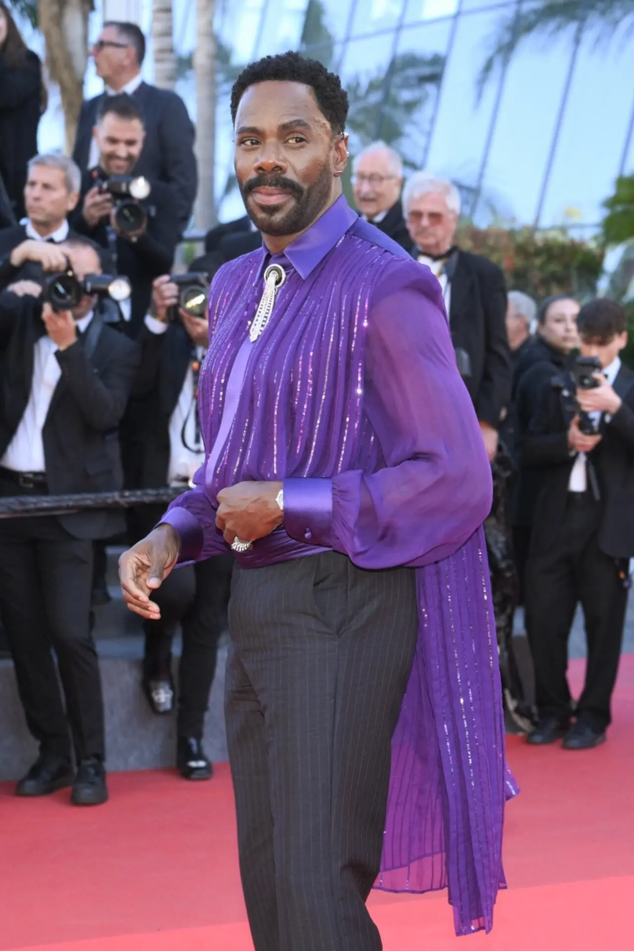 Colman Domingo made a striking appearance in a royal purple shirt featuring a glossy striped design and a sheer cape.