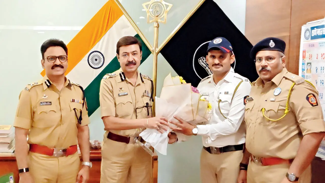 Thane traffic cop honoured after dramatic 8-km chase of stolen SUV Thane Police Commissioner Ashutosh Dumbre (second from left) felicitates traffic constable Ashru Hake. Pics/Ashru Hake