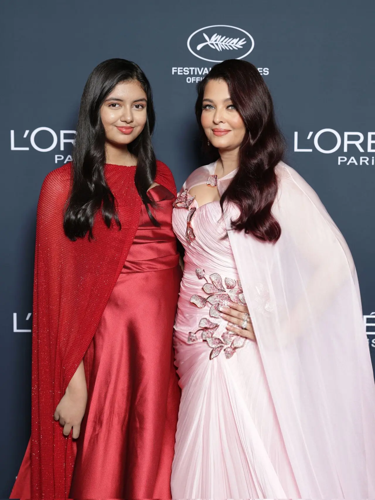 Standing beside her was her teenage daughter Aaradhya Bachchan who complemented her mother beautifully in a satin red gown paired with a sparkling cape detail Standing beside her was her teenage daughter Aaradhya Bachchan who complemented her mother beautifully in a satin red gown paired with a sparkling cape detail