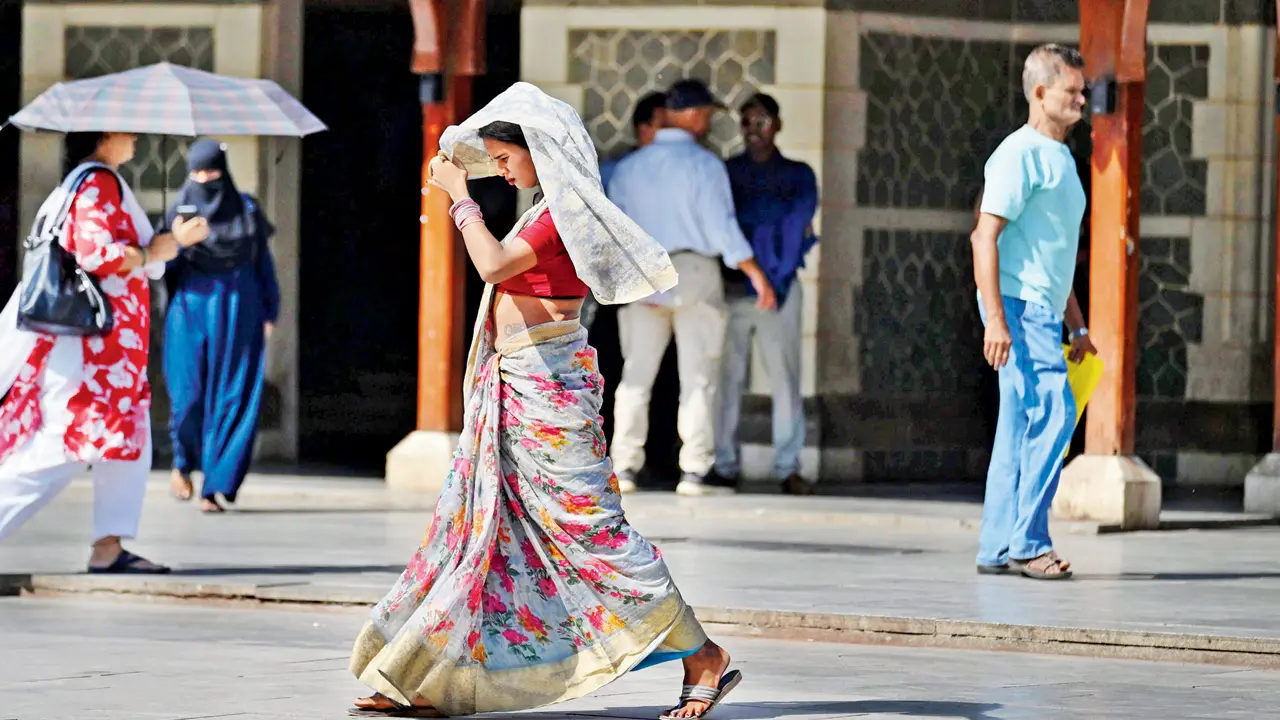 Commuters navigate the afternoon heat in Bandra amid rising temperatures and humidity in Mumbai. Pic/Atul Kamble
