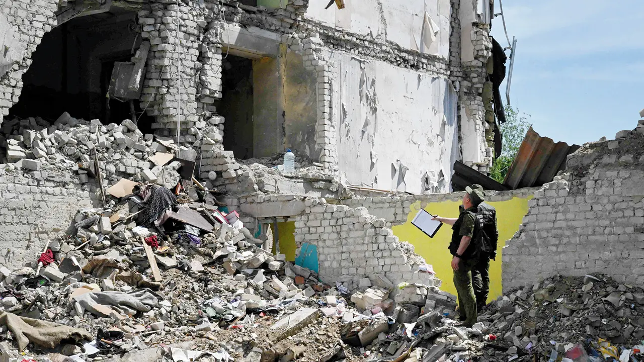 Russian investigators work at the site of the destroyed Starobilsk college dormitory building, following a drone attack. PIC/AFP