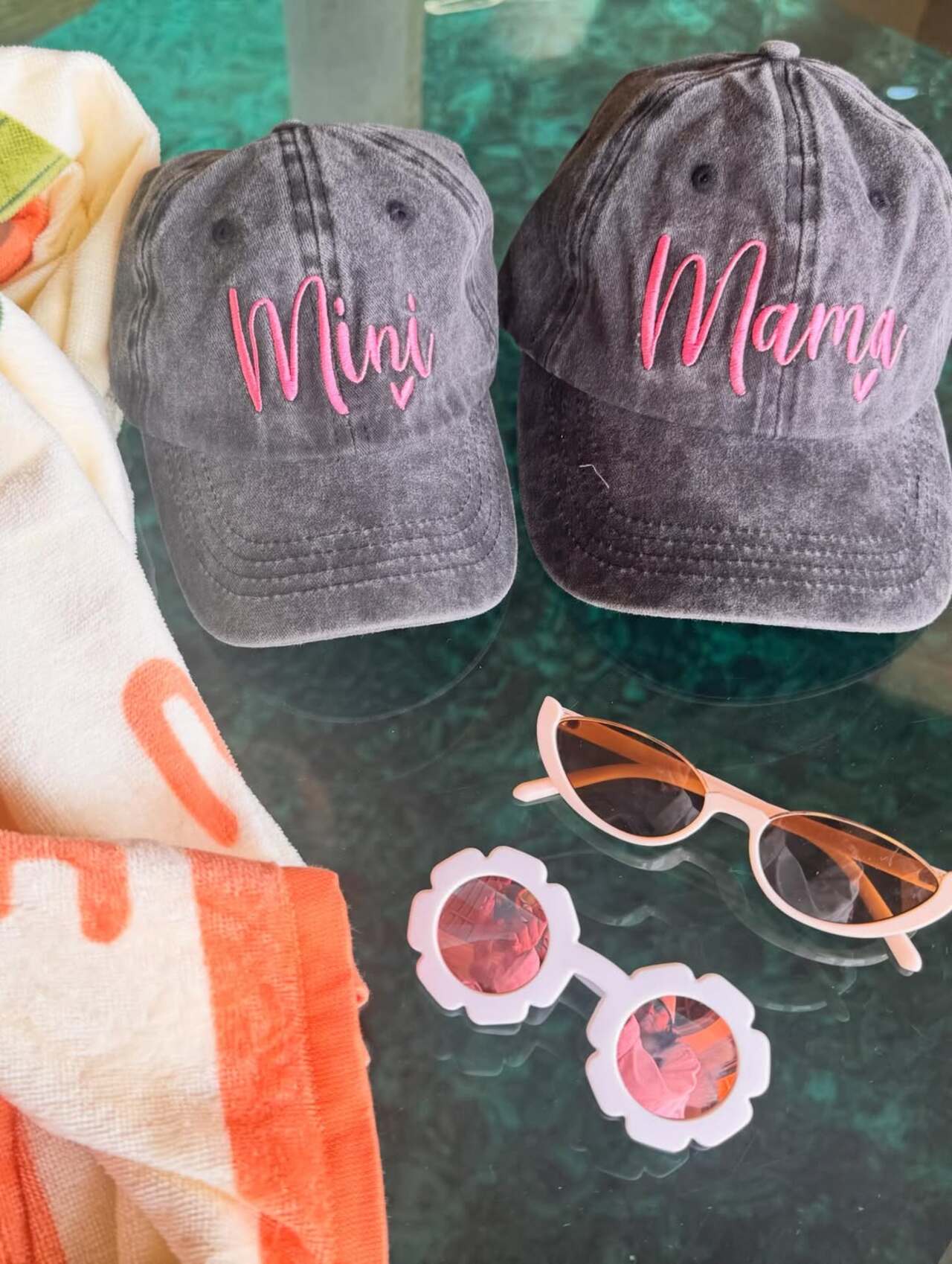 A sweet detail shot shows matching caps that read &ldquo;Kiara Mini&rdquo; and &ldquo;Mama,&rdquo; placed alongside tiny sunglasses, hinting at little Saraayah&rsquo;s adorable beach style.