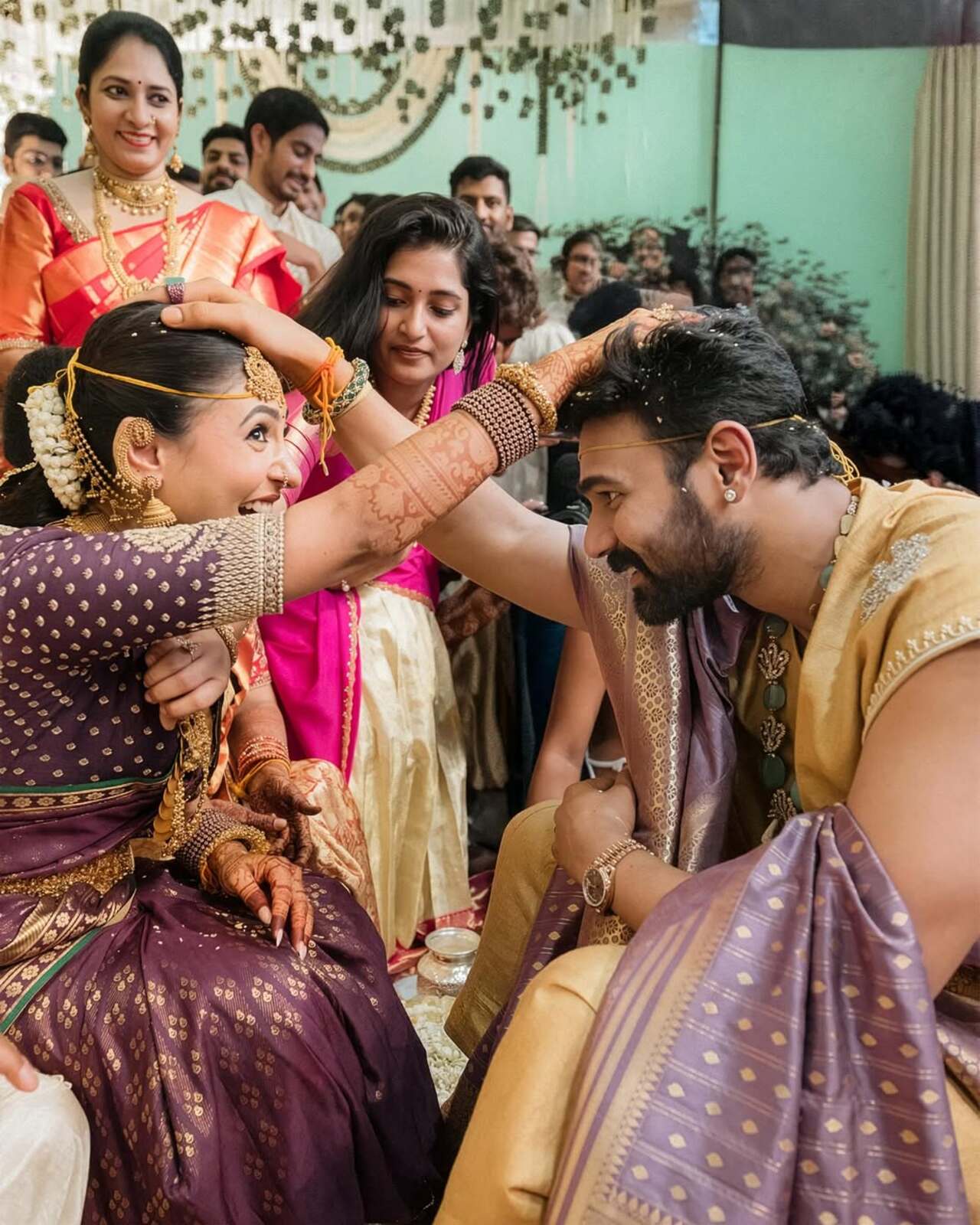 Kavya is dressed in a rich purple silk saree with intricate gold jewelry, while Sreenivas wears a coordinated traditional dhoti and shawl in one of the ceremony.