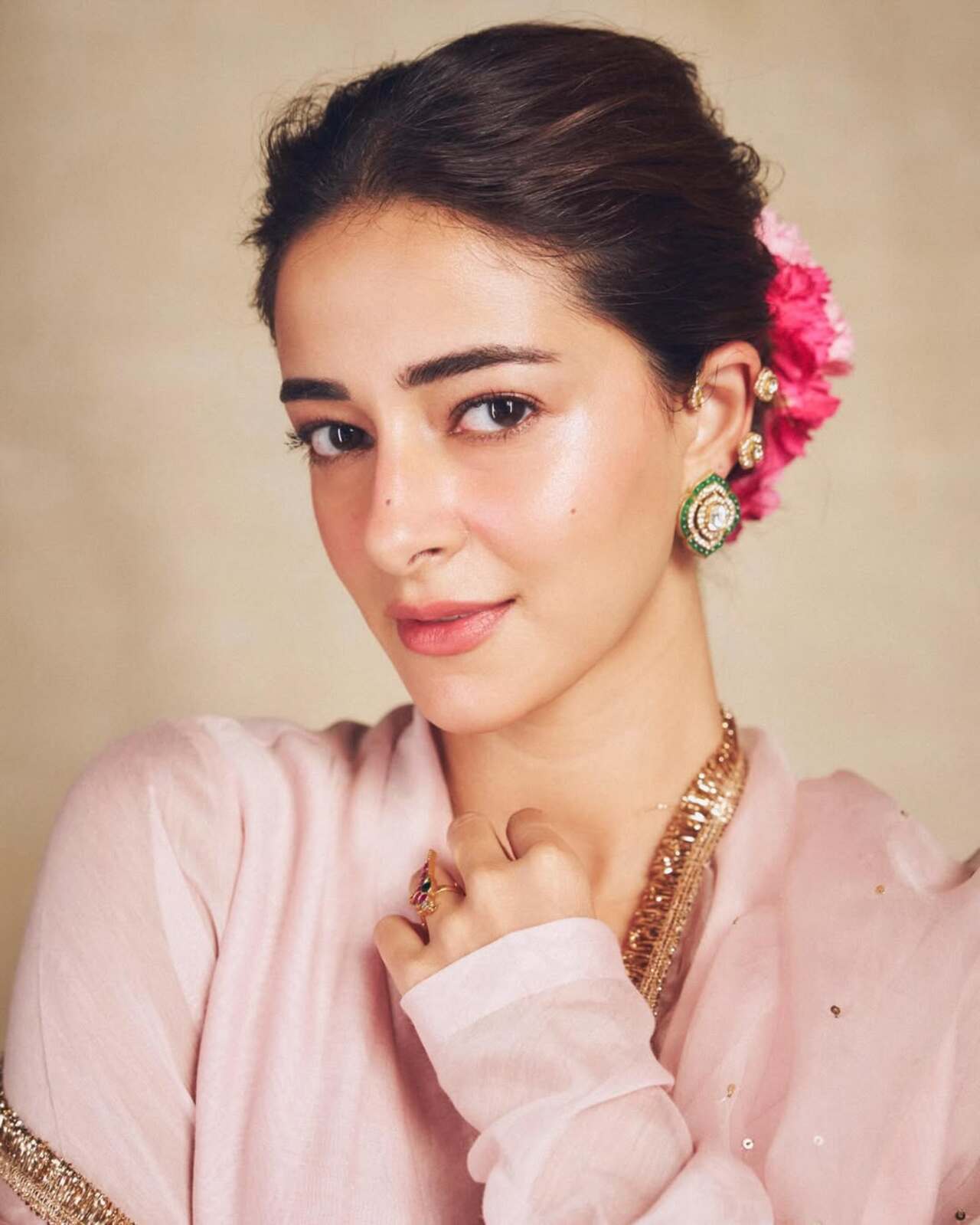 To complement the romantic outfit, her hair was elegantly pinned into a soft bun adorned with fresh pink and white flowers. To complement the romantic outfit, her hair was elegantly pinned into a soft bun adorned with fresh pink and white flowers.