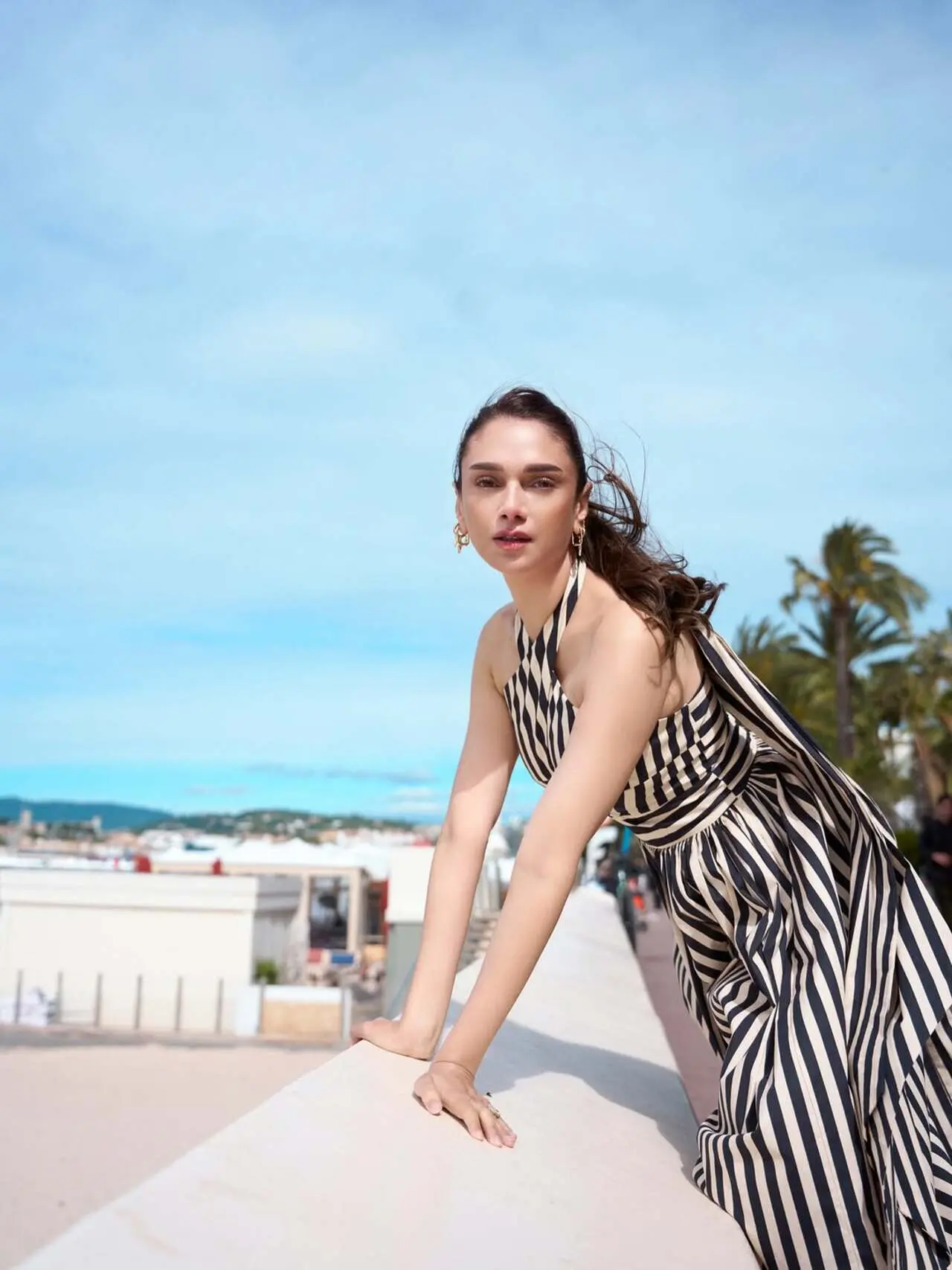 The halter-neck silhouette and dramatic striped detailing gave the look a chic retro vibe, while her sleek ponytail and tinted sunglasses added effortless sophistication. The halter-neck silhouette and dramatic striped detailing gave the look a chic retro vibe, while her sleek ponytail and tinted sunglasses added effortless sophistication. 