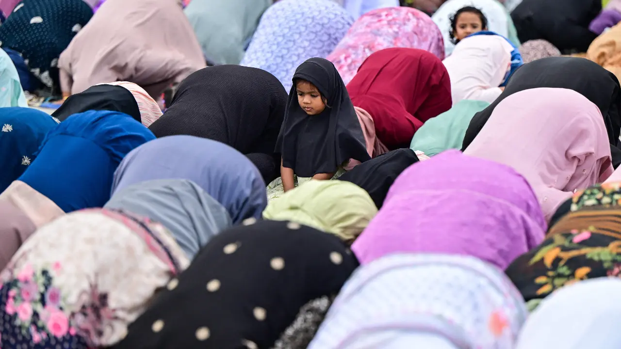 Starting the day with prayer, a child looks on as Muslim devotees offer Eid al-Adha prayers at the Galle Face Green in Colombo Starting the day with prayer, a child looks on as Muslim devotees offer Eid al-Adha prayers at the Galle Face Green in Colombo