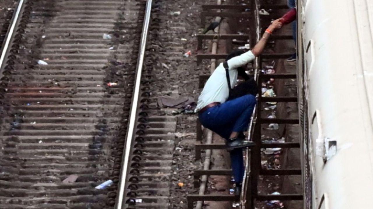 A commuter risks his life while attempting to board a moving local train at Borivali railway station. PIC/ SAYYED SAMEER ABEDI
