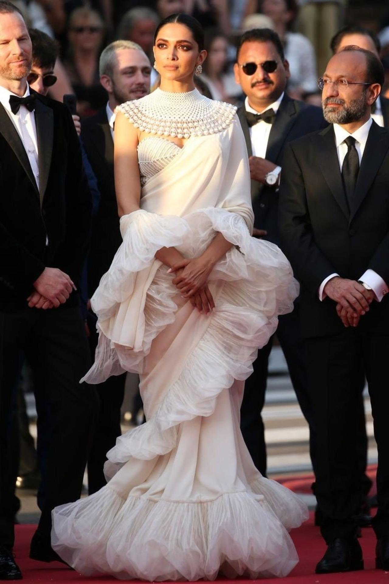 At Cannes 2022, Deepika Padukone wore a white ruffled saree designed by Abu Jani-Sandeep Khosla, featuring a high-neck pearl blouse.
