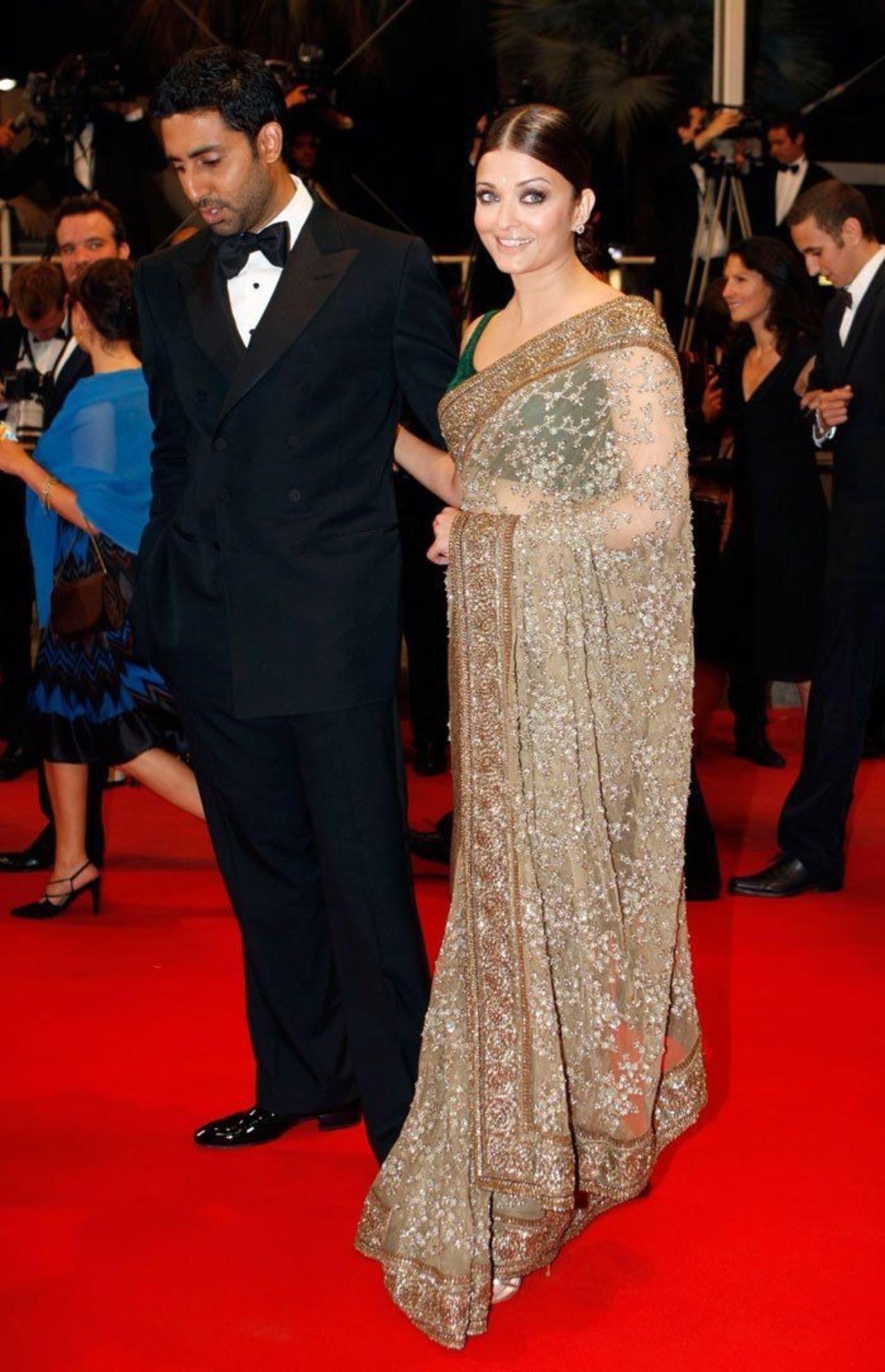 Aishwarya Rai Bachchan walked the red carpet at the Cannes Film Festival with husband Abhishek Bachchan, wearing a heavily embroidered, sheer beige net saree paired with a dark green velvet blouse.