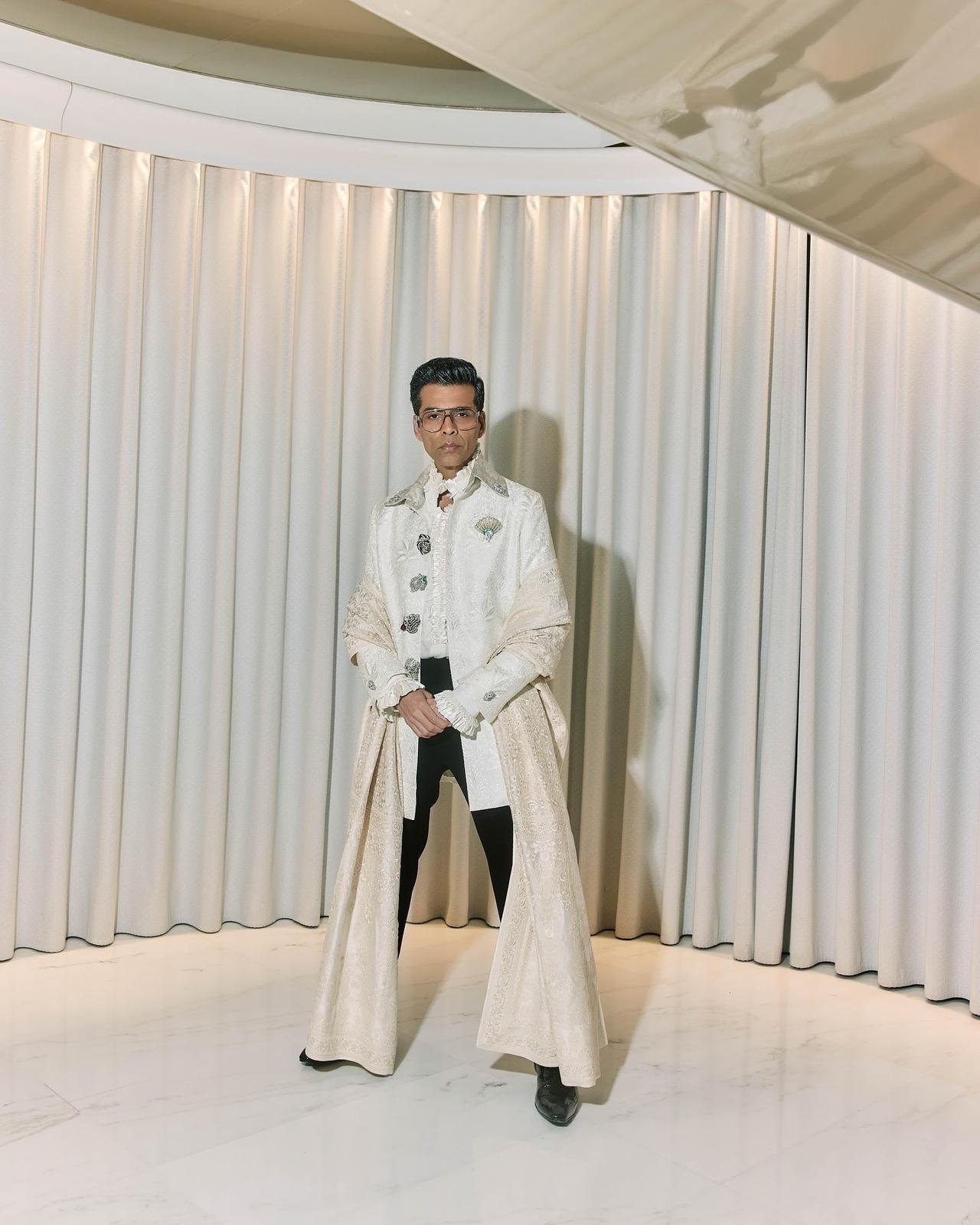 Blending the dupatta trend into men's fashion, Karan wears an ivory bandhgala layered over a ruffled shirt, accompanied by a cream zari dupatta.