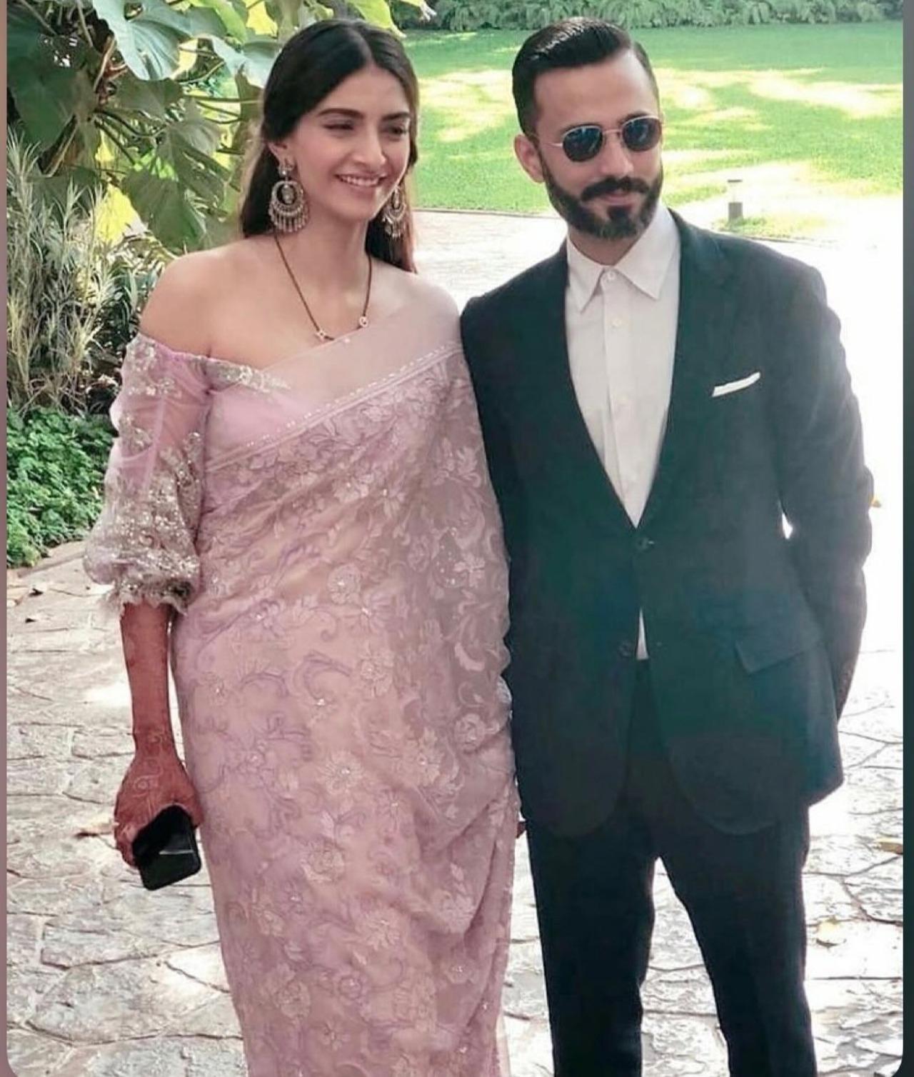 Sonam exudes the bridal glow, complete with the mangalsutra and mehendi, while wearing a pretty blush pink saree. Anand looks decked up in a classic tuxedo. Sonam exudes the bridal glow, complete with the mangalsutra and mehendi, while wearing a pretty blush pink saree. Anand looks decked up in a classic tuxedo.