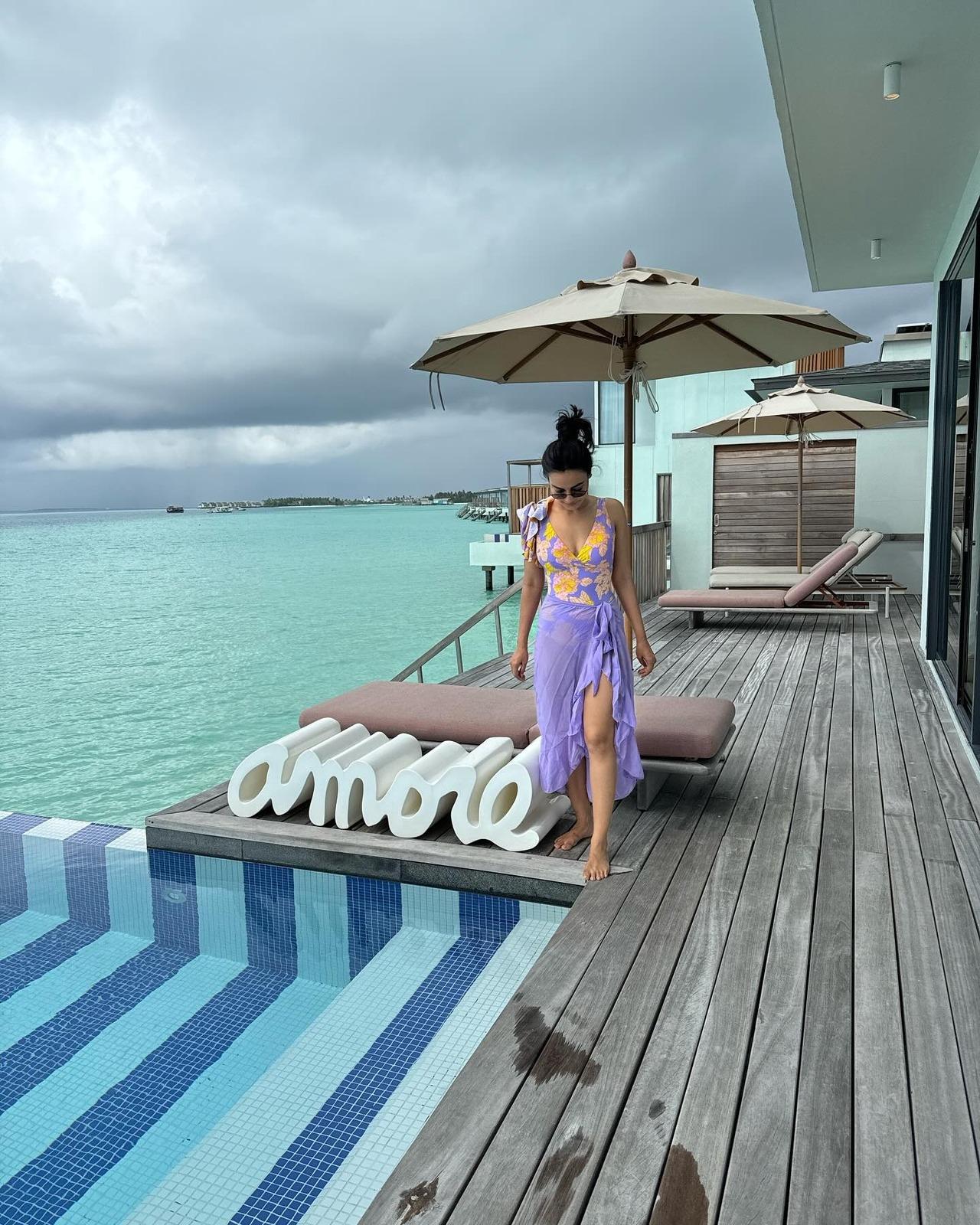 Surbhi stuns in this purple and yellow floral monokini, while pairing it with a sheer purple skirt, as she preps up for a dip in the water. Surbhi stuns in this purple and yellow floral monokini, while pairing it with a sheer purple skirt, as she preps up for a dip in the water.