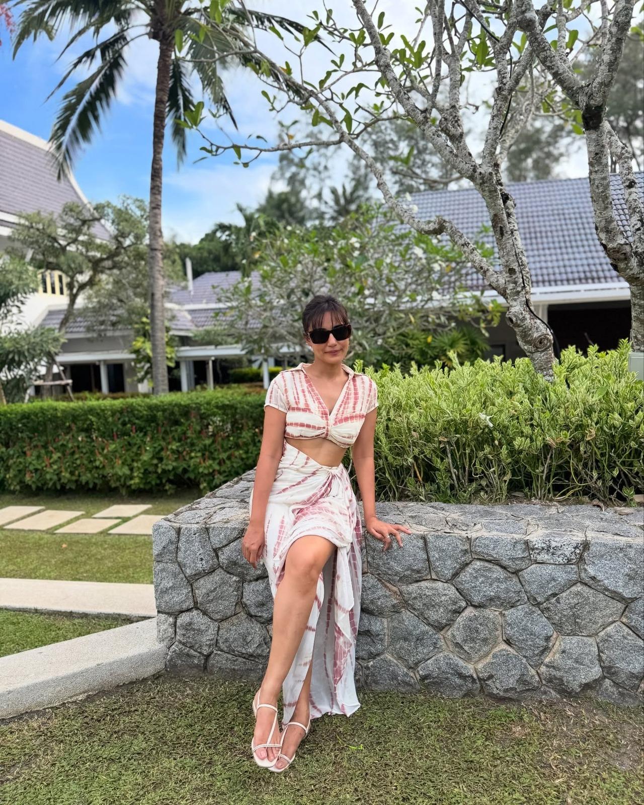 Keeping it breezy and cool, Surbhi wears a white and maroon tie-dye co-ord set, which includes a twisted crop top and a matching maxi slit skirt. Keeping it breezy and cool, Surbhi wears a white and maroon tie-dye co-ord set, which includes a twisted crop top and a matching maxi slit skirt.