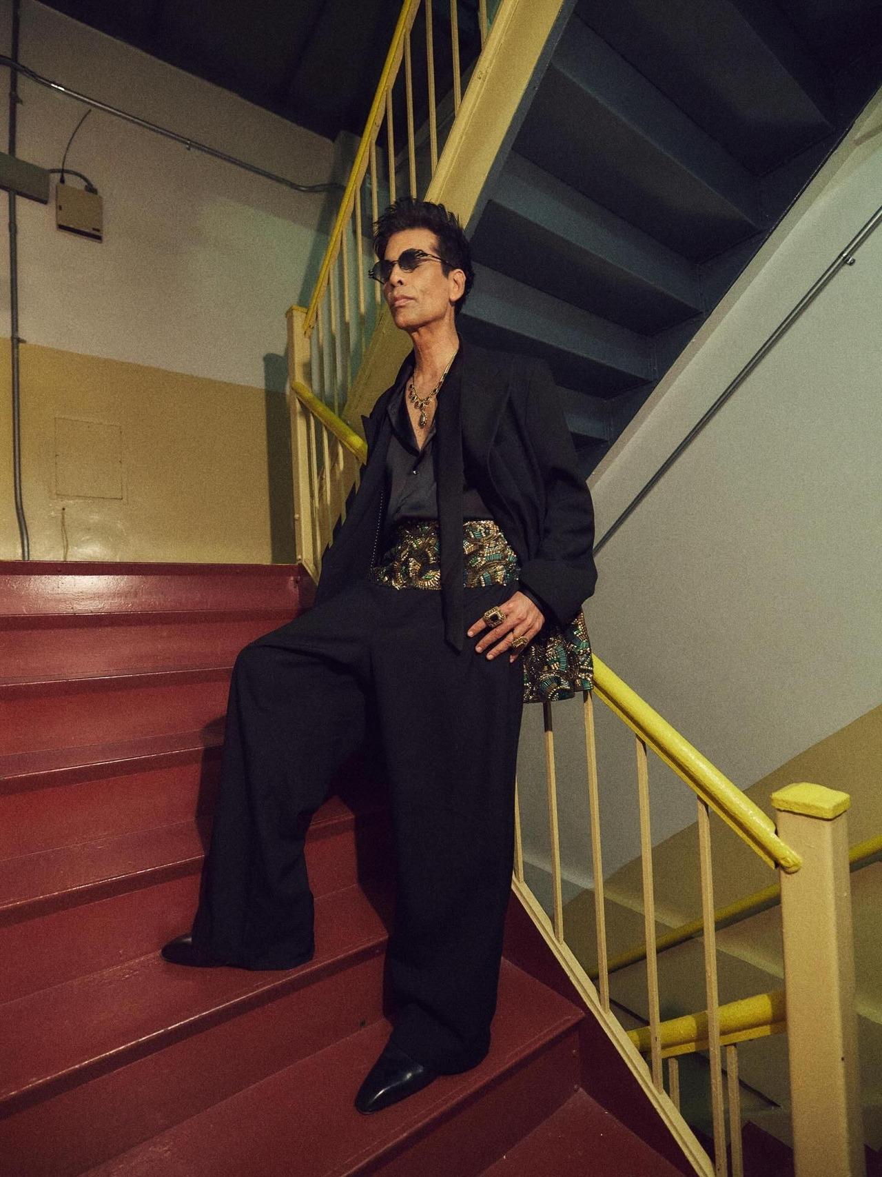 Karan wore this sharply tailored, all-black base consisting of an open-collar shirt and wide-legged, fluid trousers with a prominent, heavily embellished gold sash at the waist that incorporated traditional zardozi embroidery, during his Met Gala appearance.