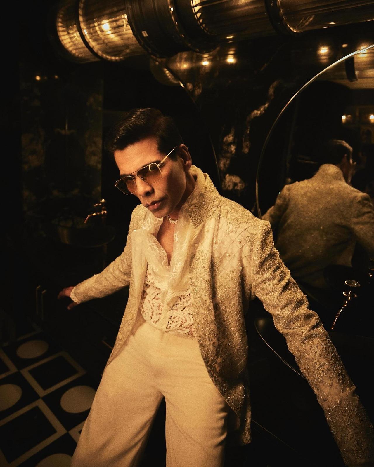 Keeping it delicate and traditional yet stylish, Karan wears an ivory, sherwani-style open jacket in organza. It featured extensive handcrafted bugle-bead and pearl embroidery, layered over a sheer lace shirt.