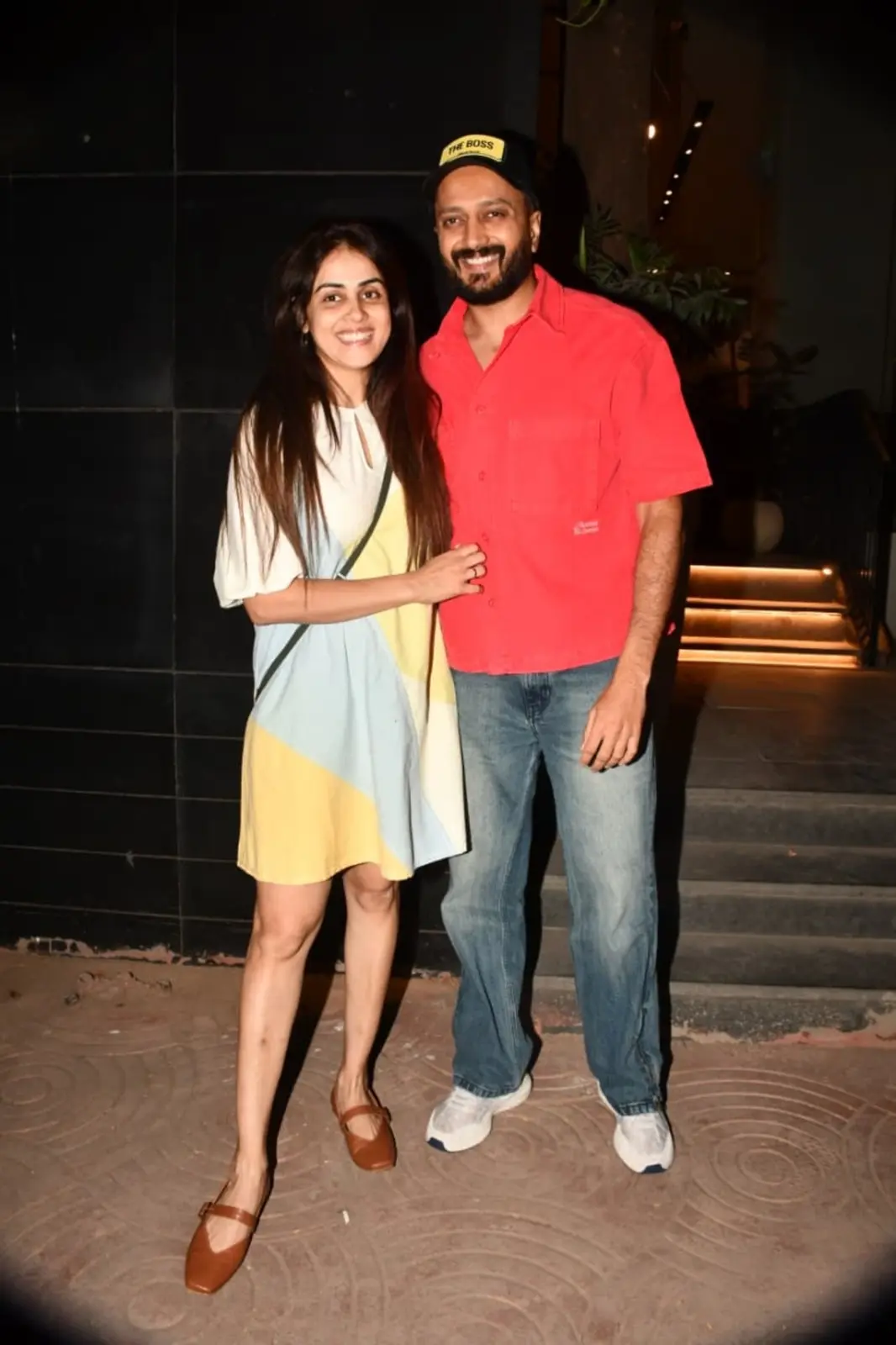 Bollywood couple Riteish Deshmukh and Genelia D'Souza were spotted together as they posed happily for the paparazzi. Genelia kept it chic in a pastel multicoloured short dress, while Riteish opted for a bright red shirt with denim jeans and a cap.