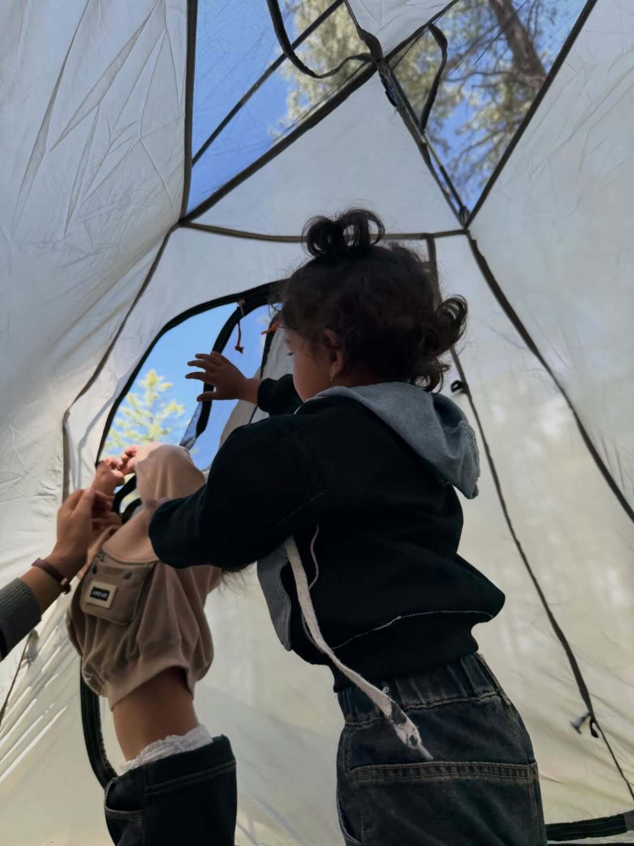 Jeeva and Edhaa's picture captures a moment where they are exploring and playing inside the tent with excitement